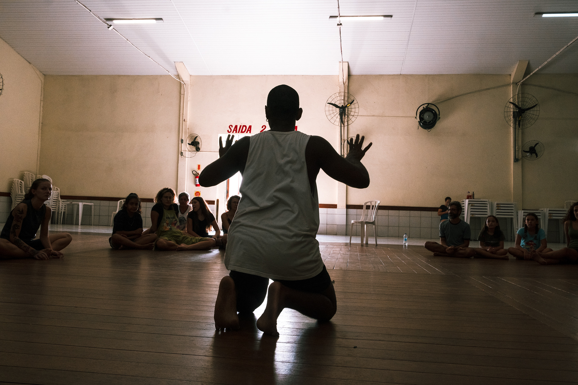 Fotografia de oficina de teatro, com iluminação natural e estética documental.