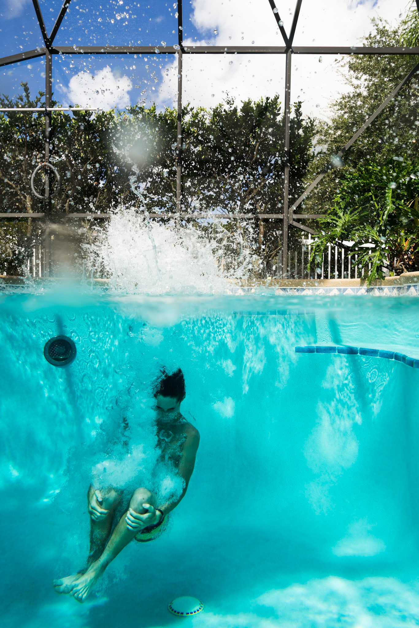 Teenager jumping into a swimming pool