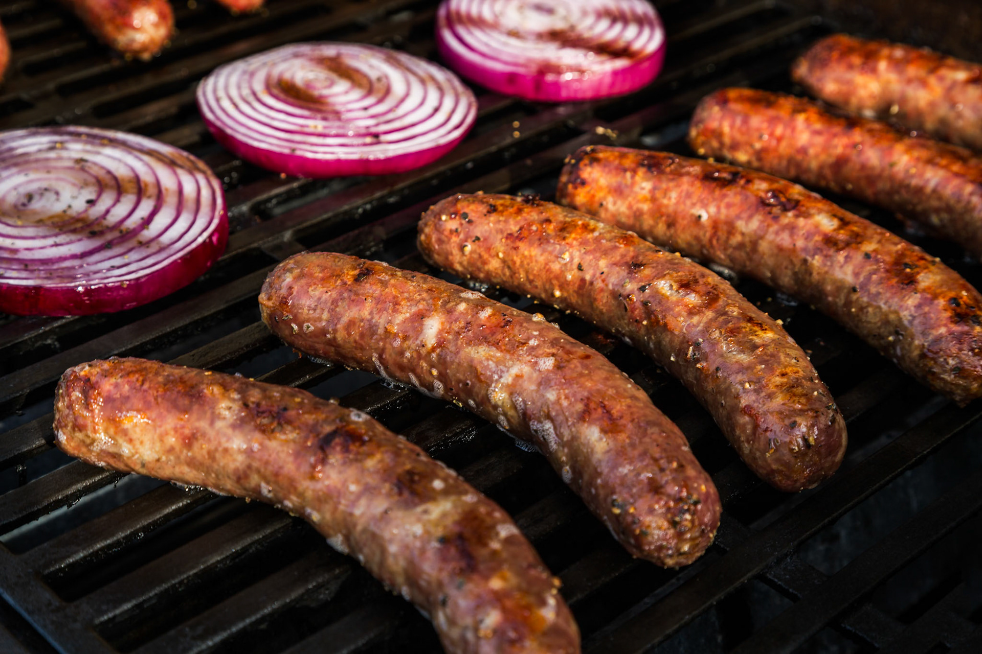 Bratwurst, Kielbasa and red onion on the grill