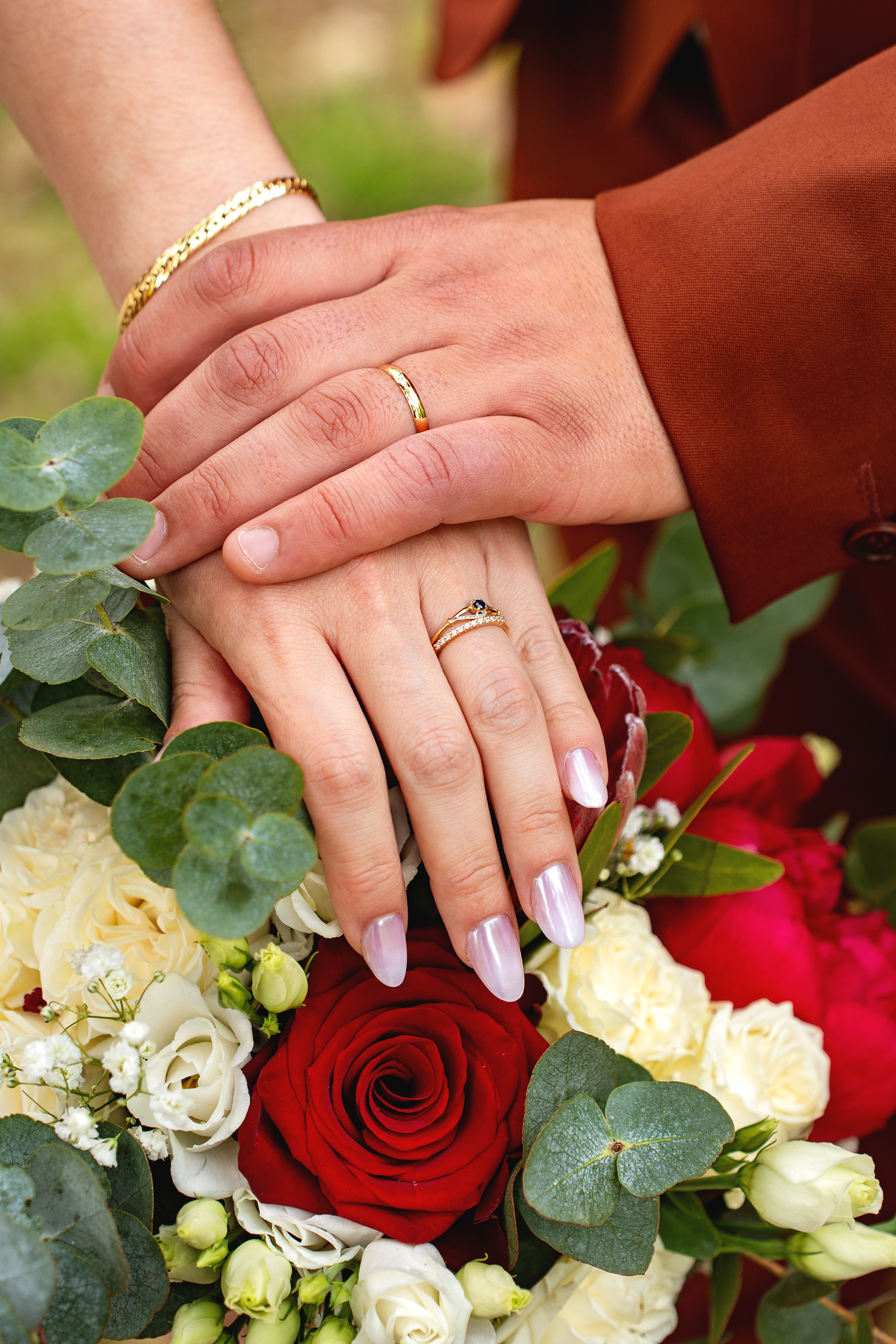 Photo des mains des mariés avec les alliances à leur mariage