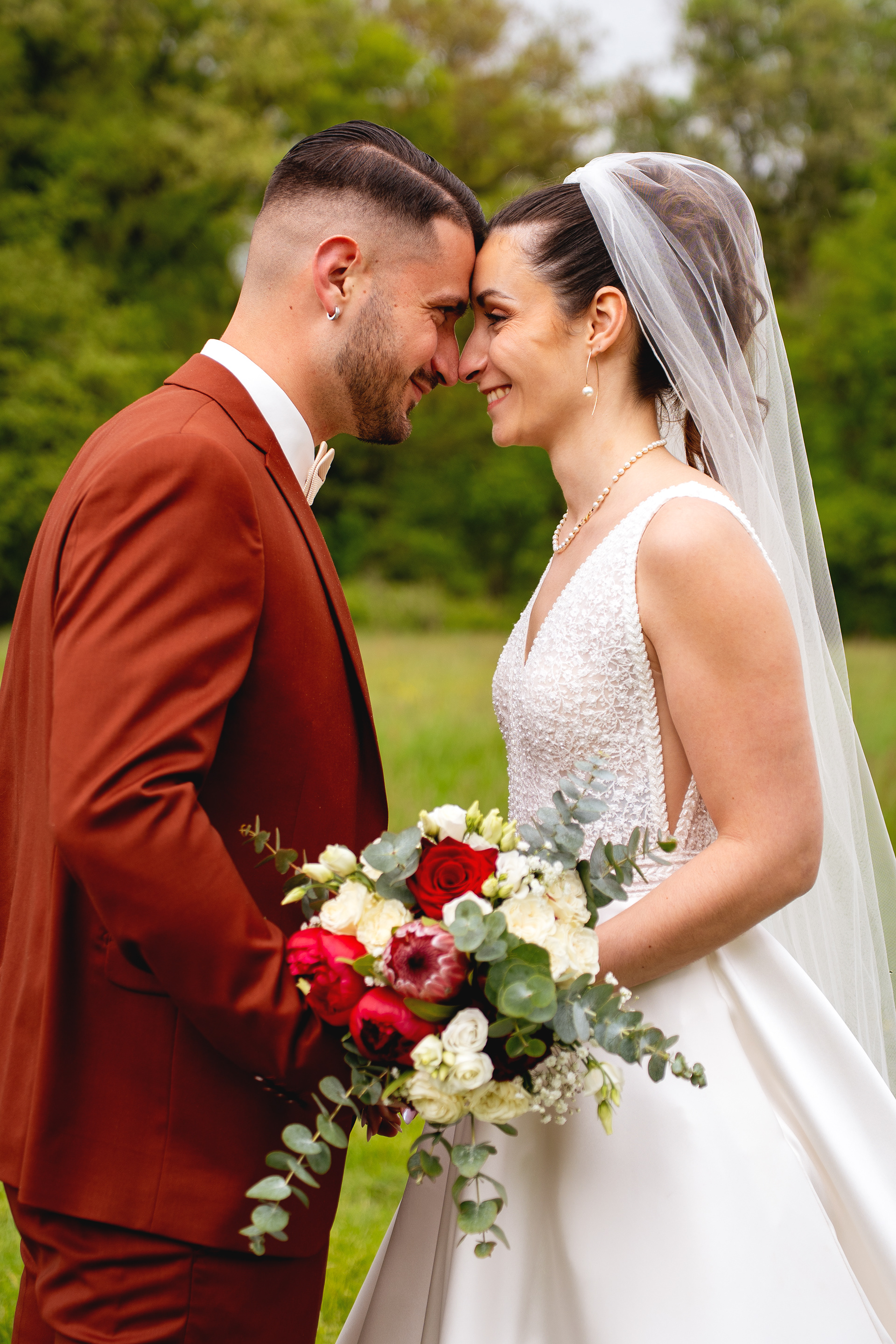Photo d'un couple de mariés avec bouquet de fleurs à leur mariage