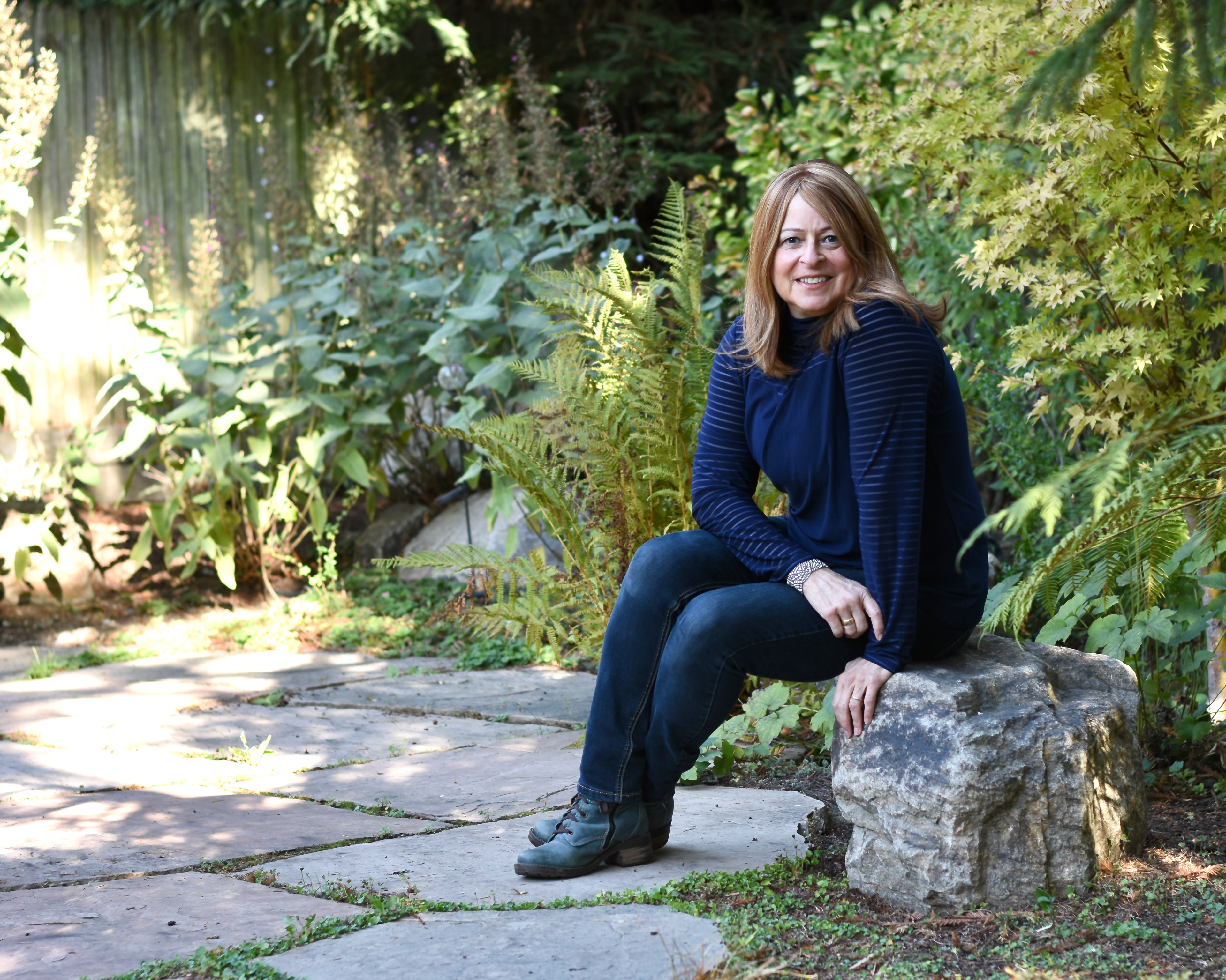 Professional portrait of a woman sitting on a rock outside by William Wayland