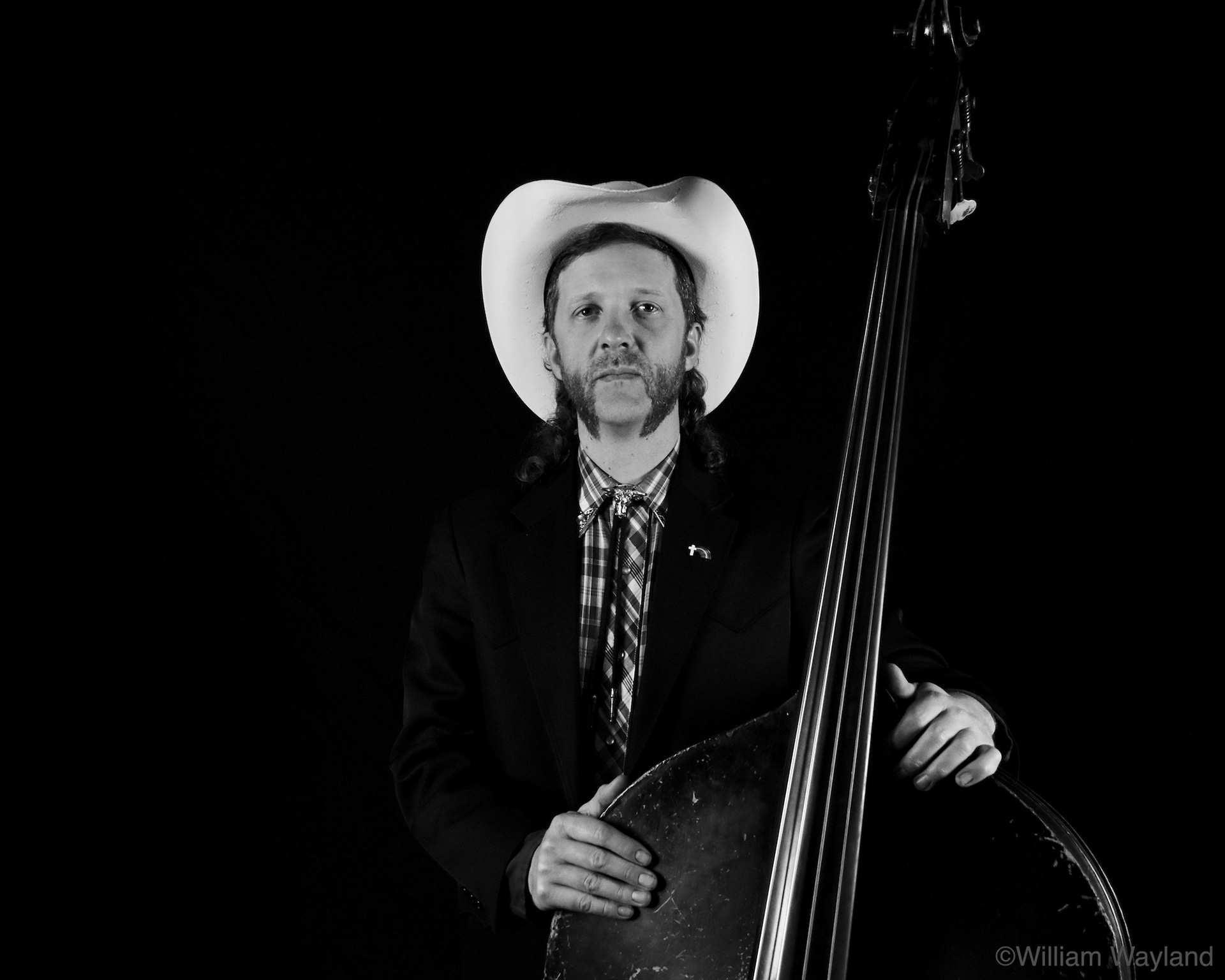 Black and white portrait of bass player wearing a cowboy hat