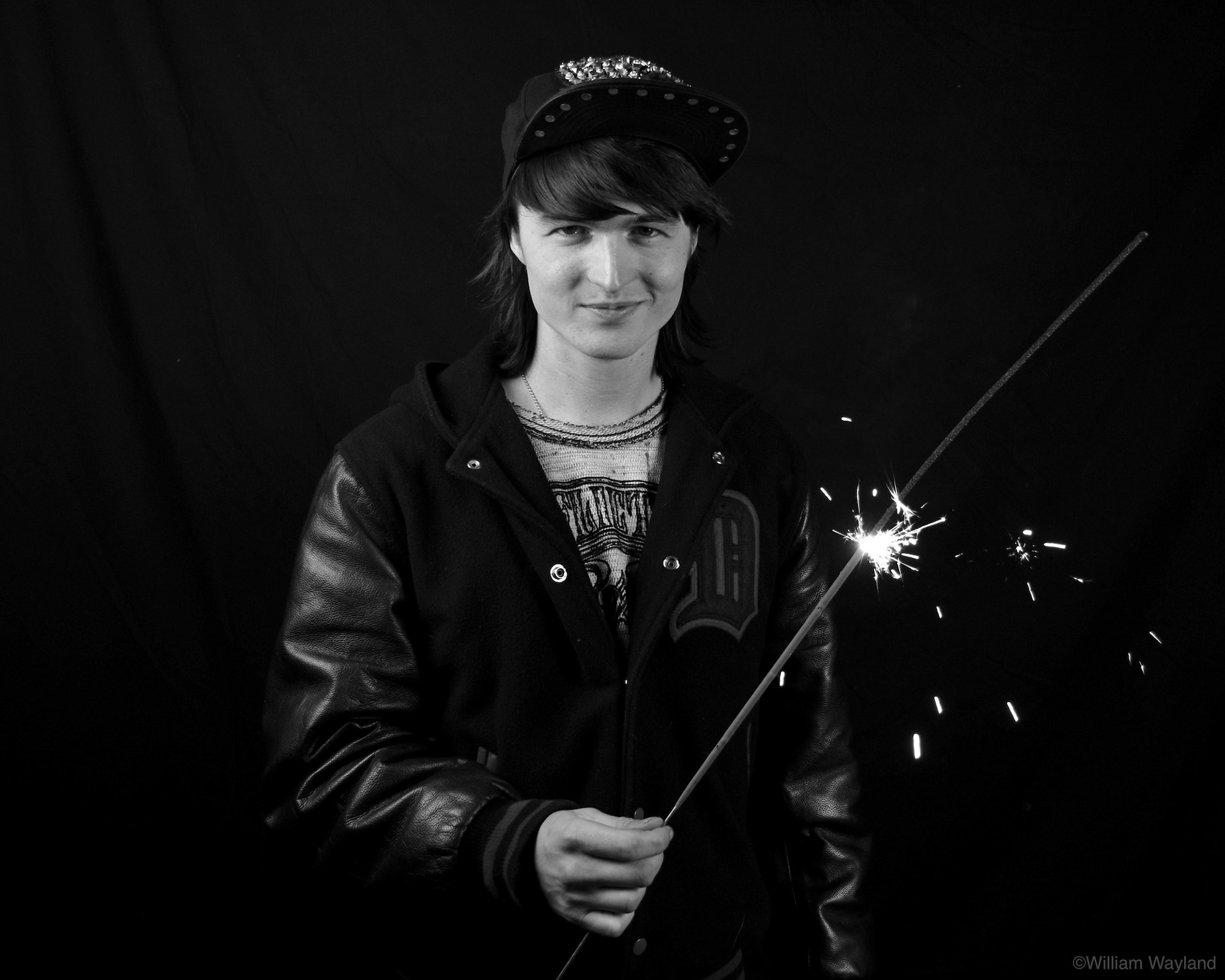 Black and white portrait of a young man with a sparkler