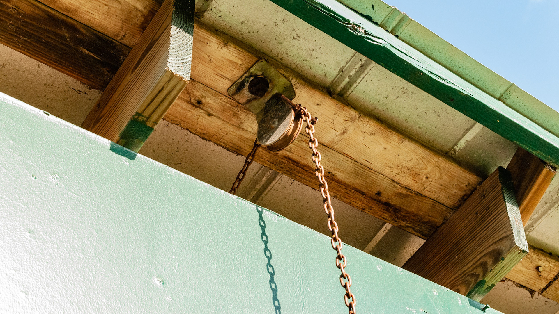 This is part of a complex arrangement of cables, pulleys, levers and springs that allowed someone on the front side of the stall to open or close the back door of the stall.
