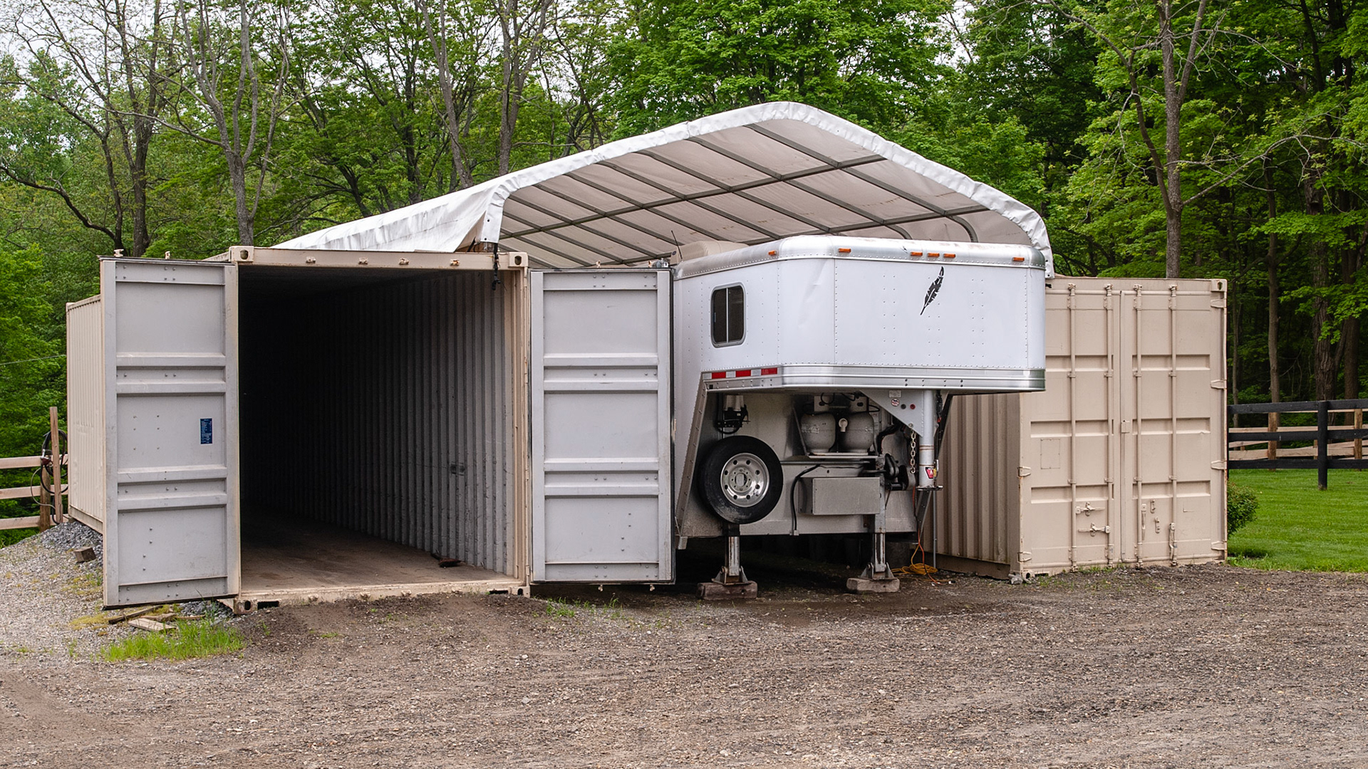 Two storage containers for feed, bedding or equipment form 2 walls of this trailer shed.