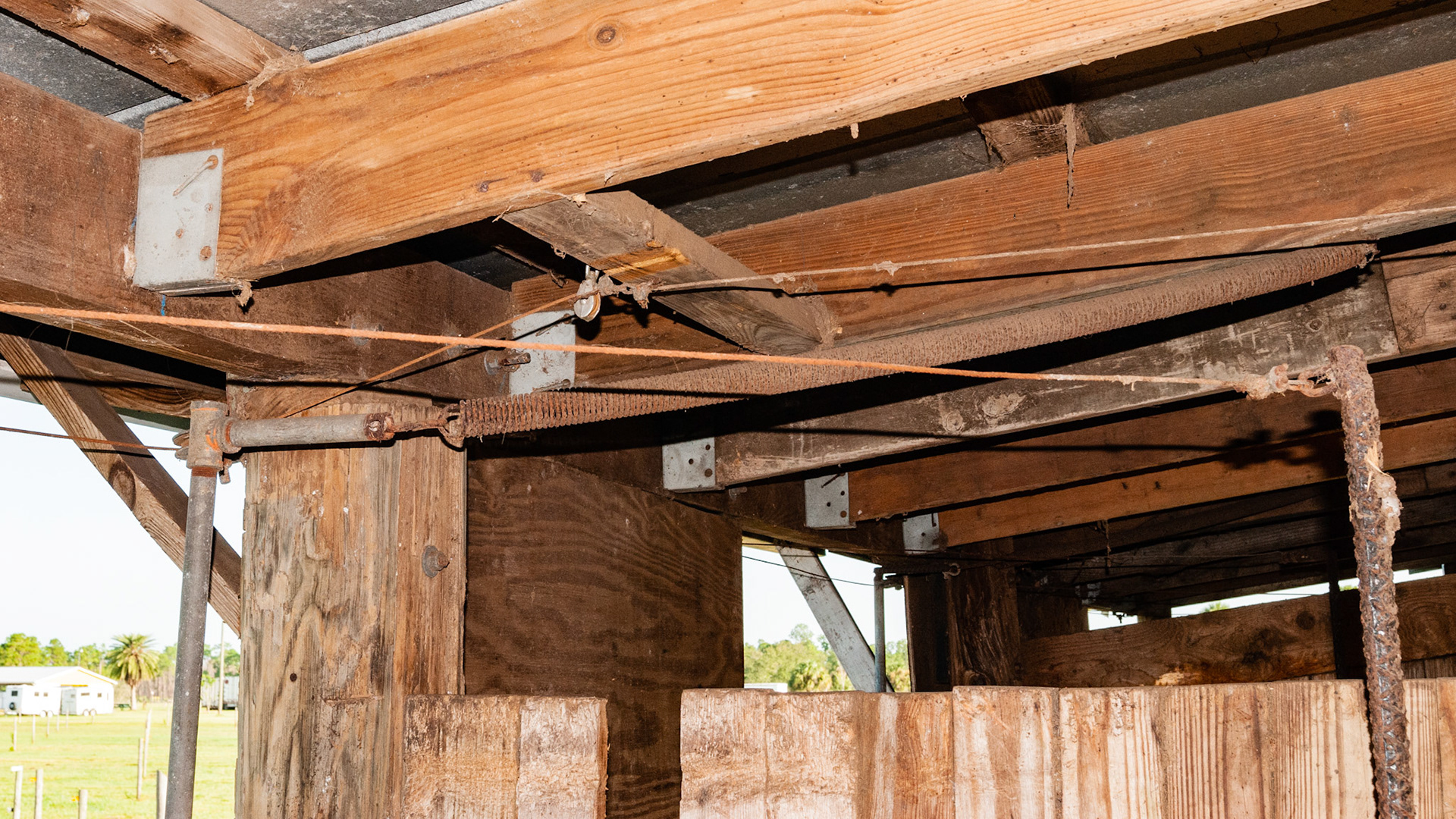 This is part of a complex arrangement of cables, pulleys, levers and springs that allowed someone on the front side of the stall to open or close the back door of the stall.