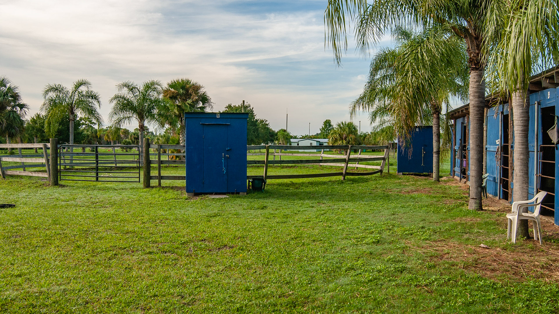 Outdoor round pen with slanted away walls to prevent riders from catching their legs in the fence