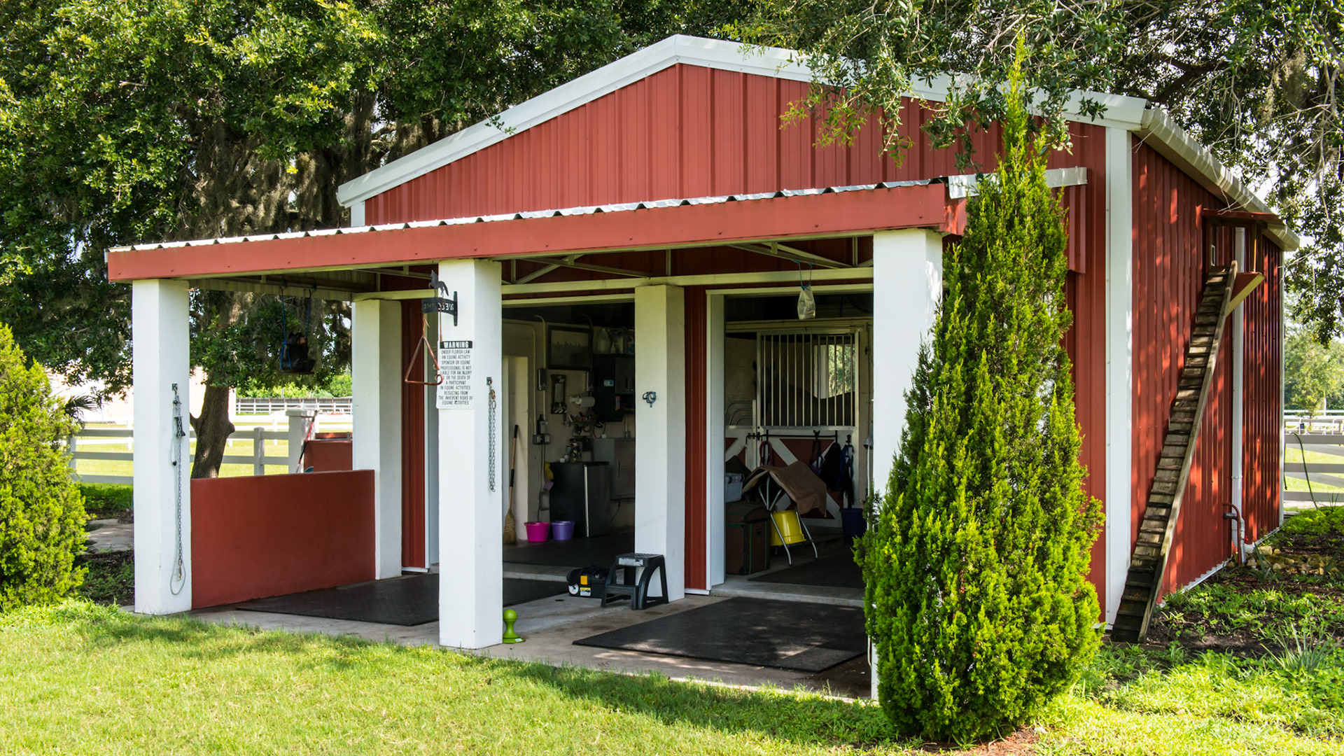 This well thought out barn for 2 horses has side by side grooming areas, 2 hurricane proof roll up doors, a general working area, and 2 stalls that lead through 2 more roll up hurricane doors to turn out paddocks.