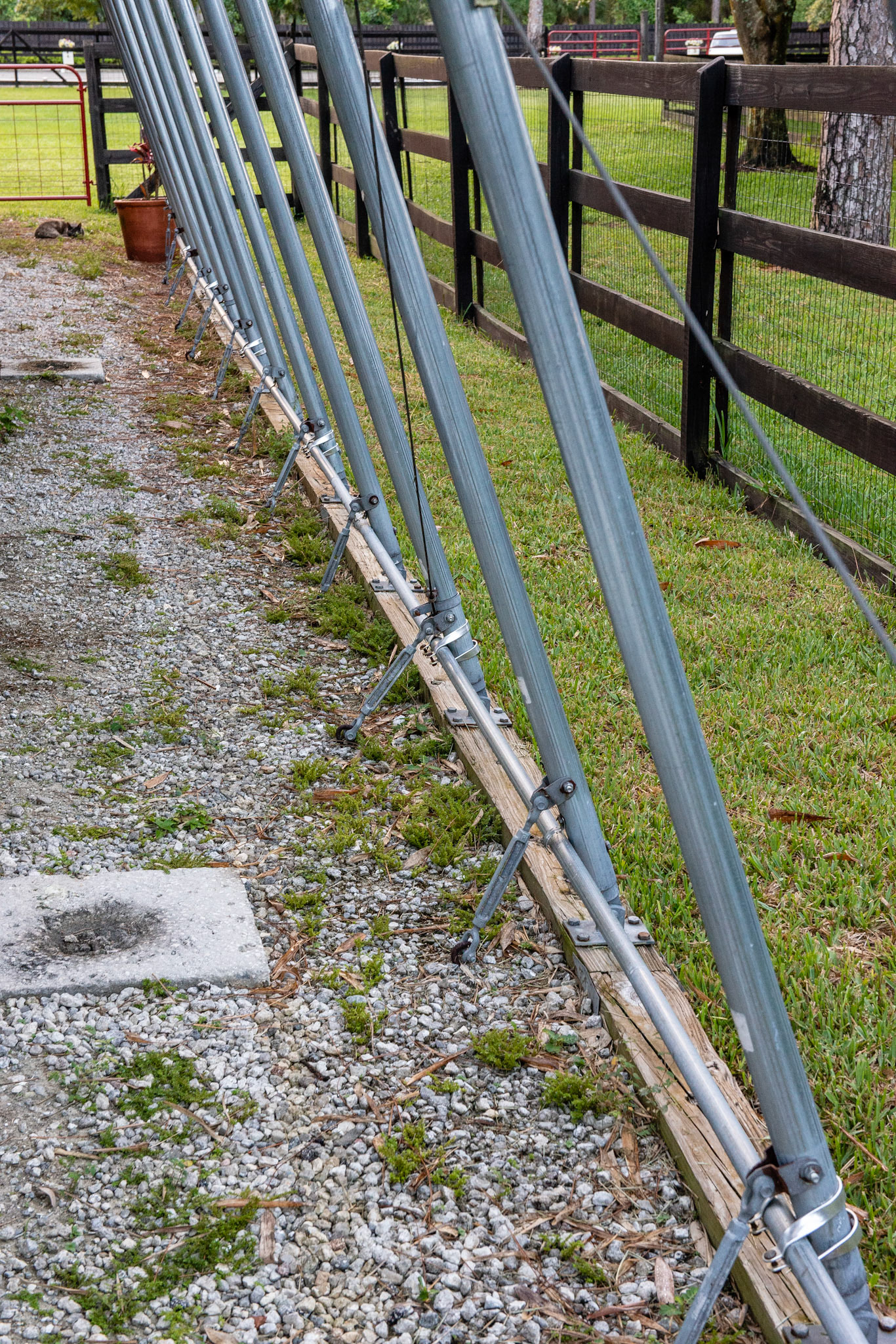 Trailer tent covering in a Quonset style. Struts are anchored deep in the ground to brace against strong winds.