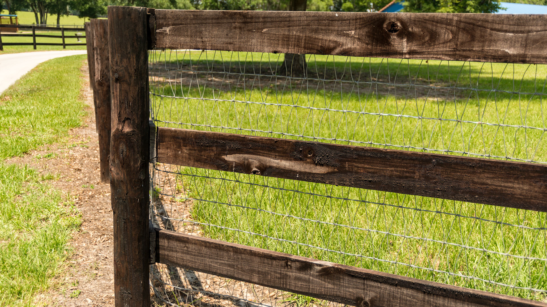 Diamond mesh woven wire fence with 3 board fencing