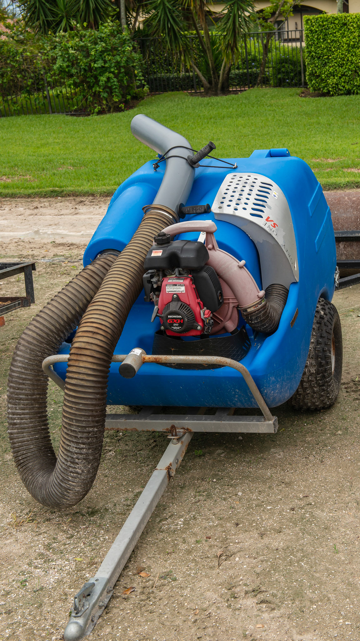 A Greystone manure vacuum with hose attached.  The black handle attached to the hard plastic helps the operator sitting on the pulling tractor to aim the tip to the pile.