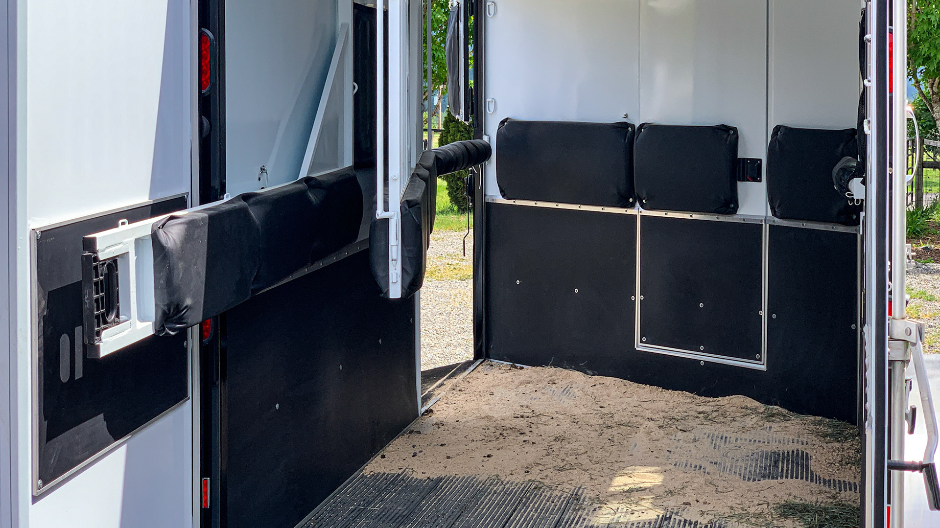 See the wide open space making this a horse friendly trailer.  Soft padding above and hard padding where kicking can occur.  The floor is a hard and grooved plastic.