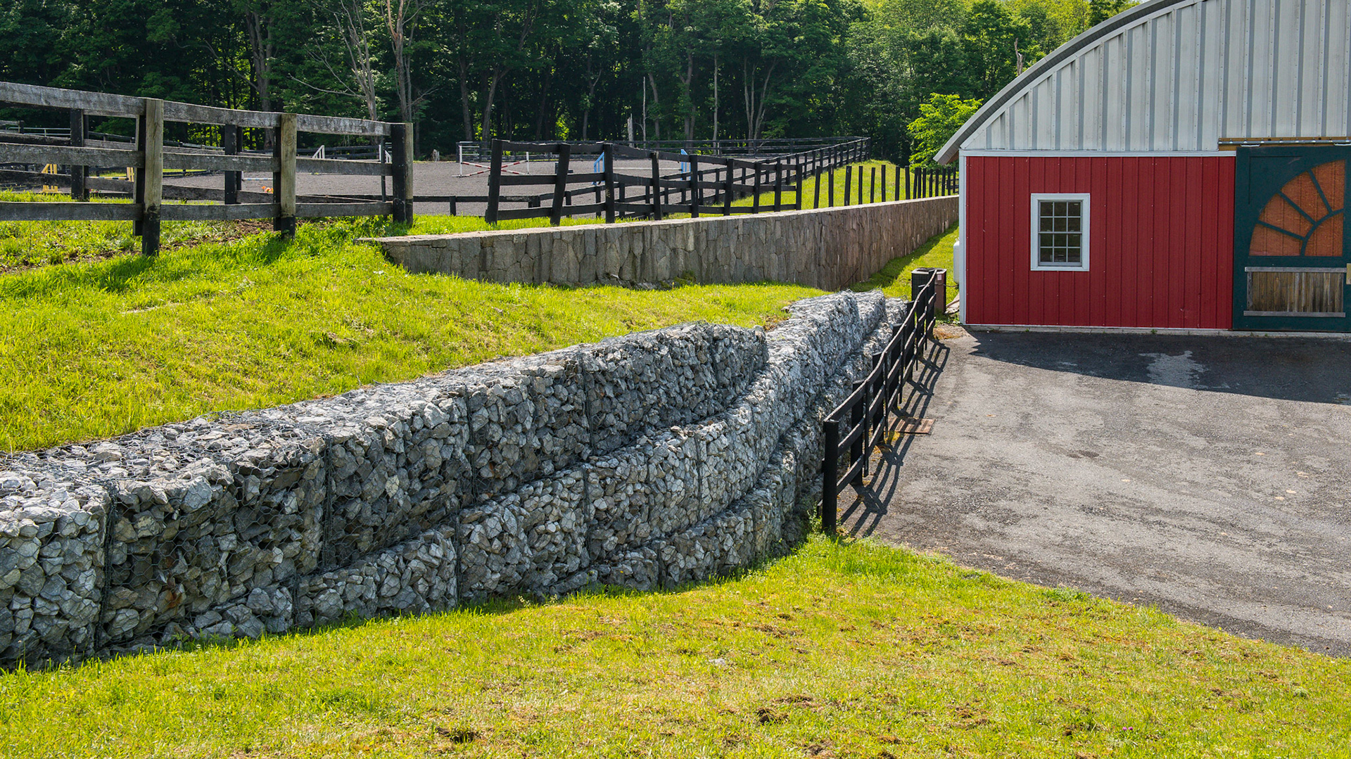 Retaining walls - one made of wired bales of stones and the other made of fitted cut stones.