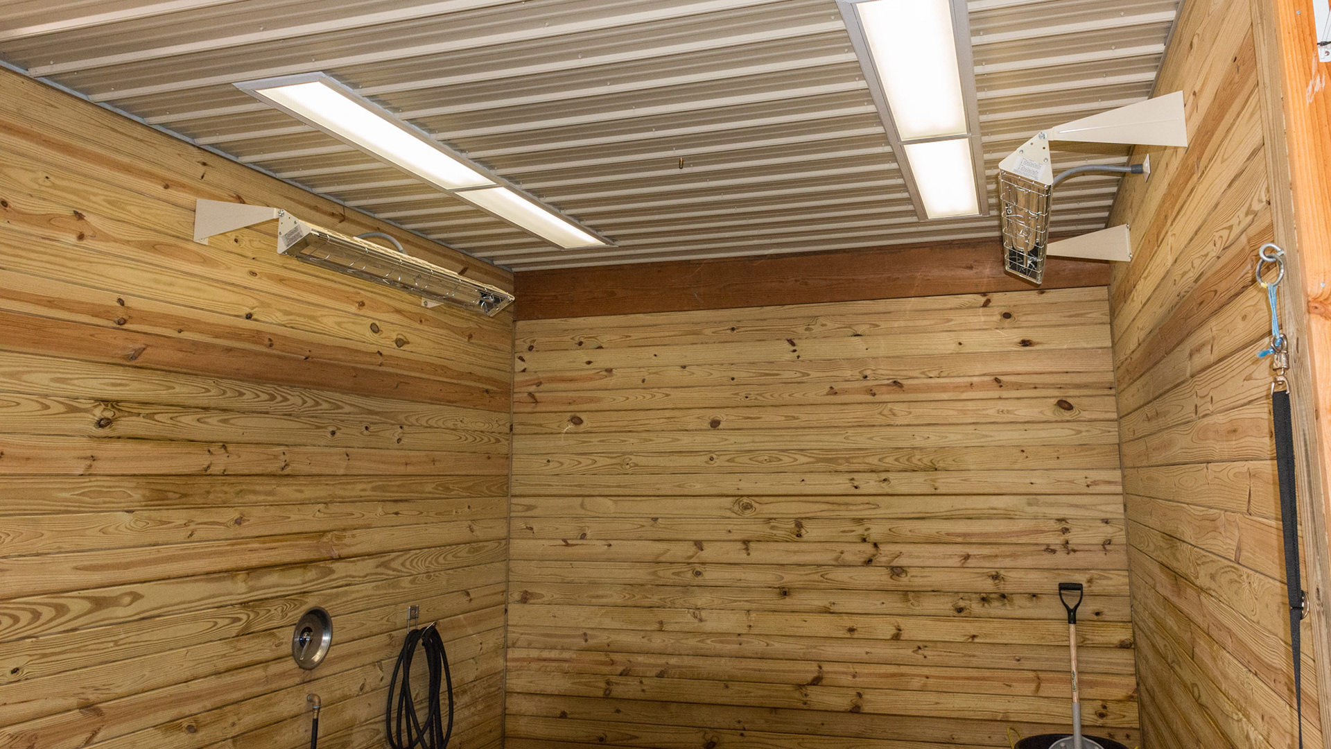 Wash stall with 2 electric radiant heaters and 2 ceiling lights located offset from center. This provides for great lighting of the sides of the horse as well as avoids light damage if a horse rears.