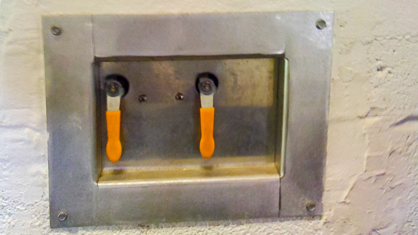 Recessed handles control water flow into individual buckets inside the stall.
