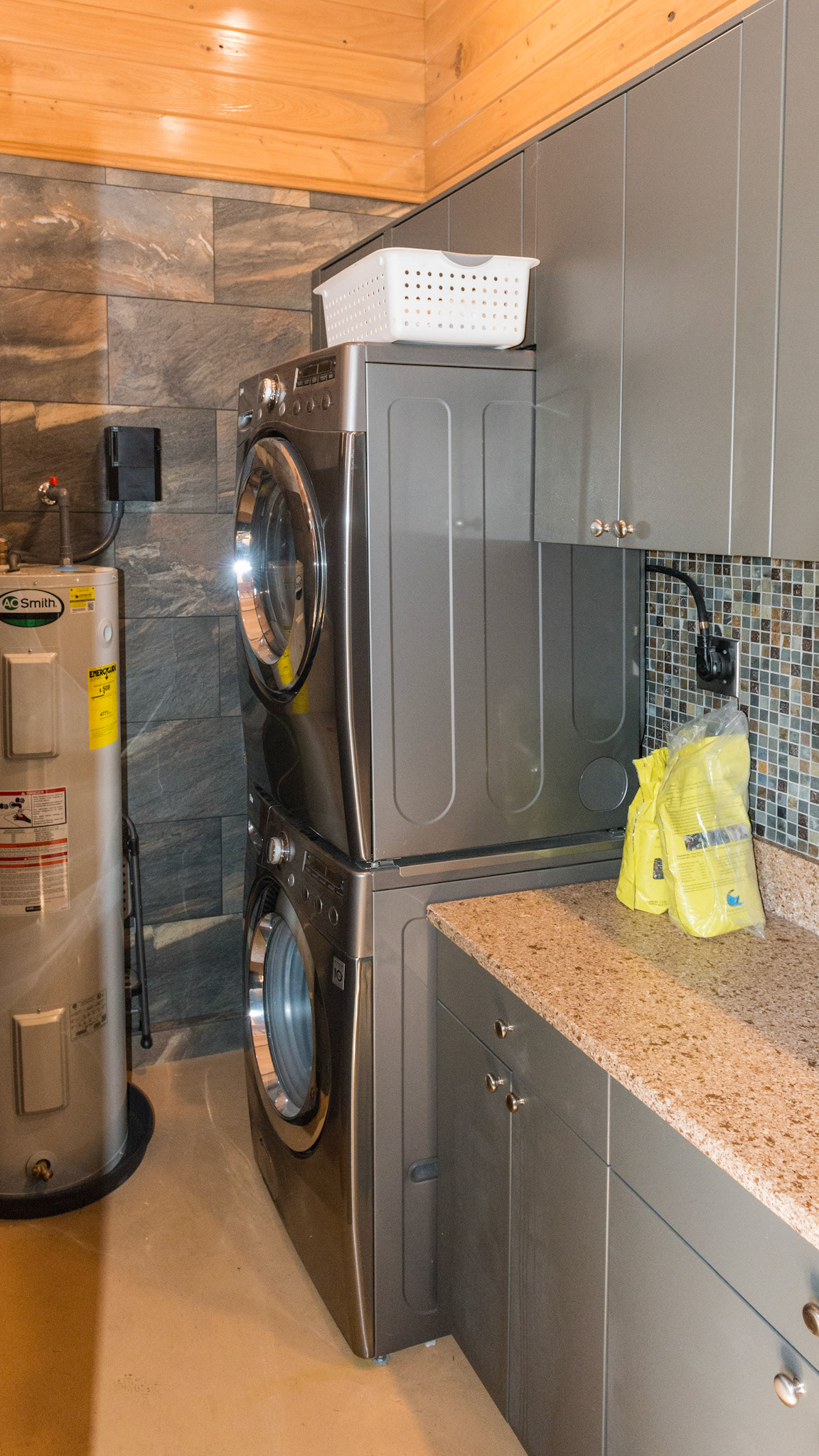 Behind the wash stall wall is this feed room with  laundry and prep area with water resistant cabinets. as well as the hot water heater.
