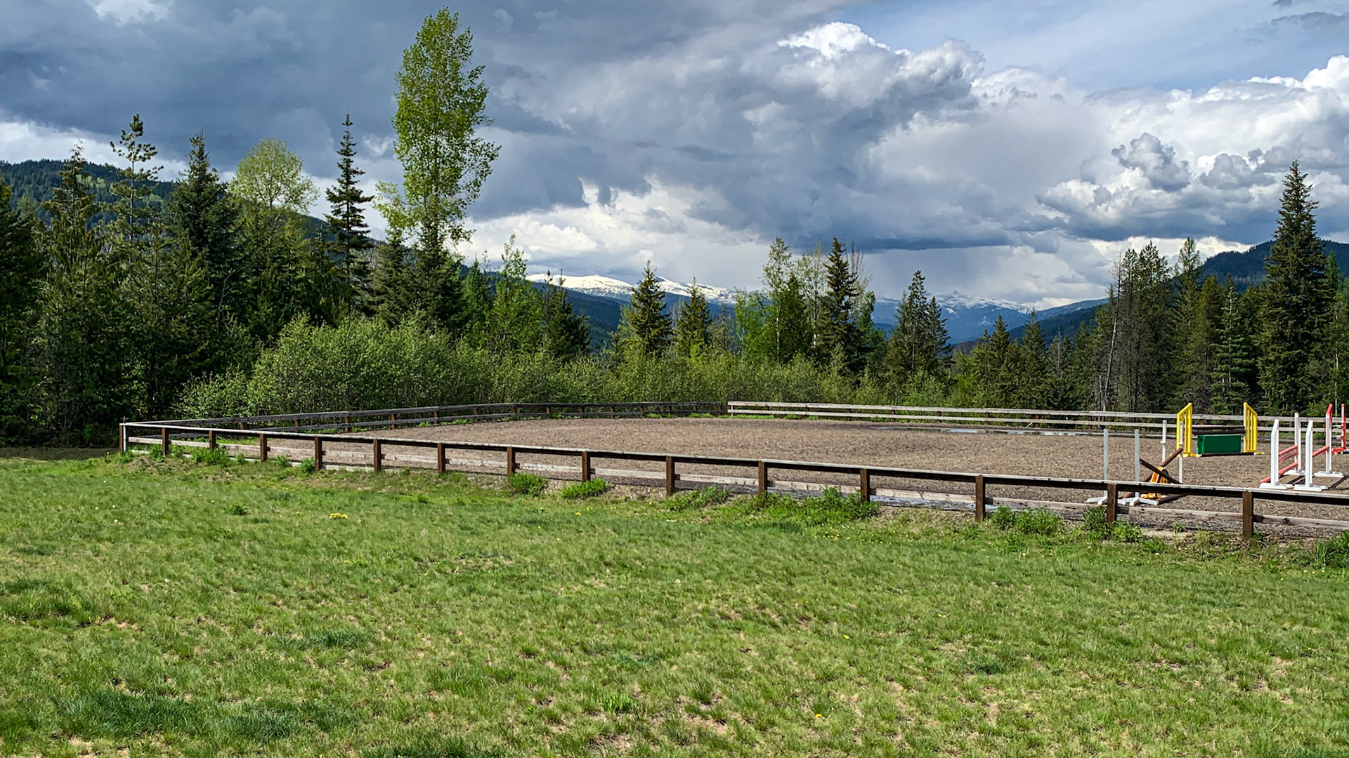 An outdoor riding arena with jumps. For use in warmer weather.  The indoor is behind me for winter use.