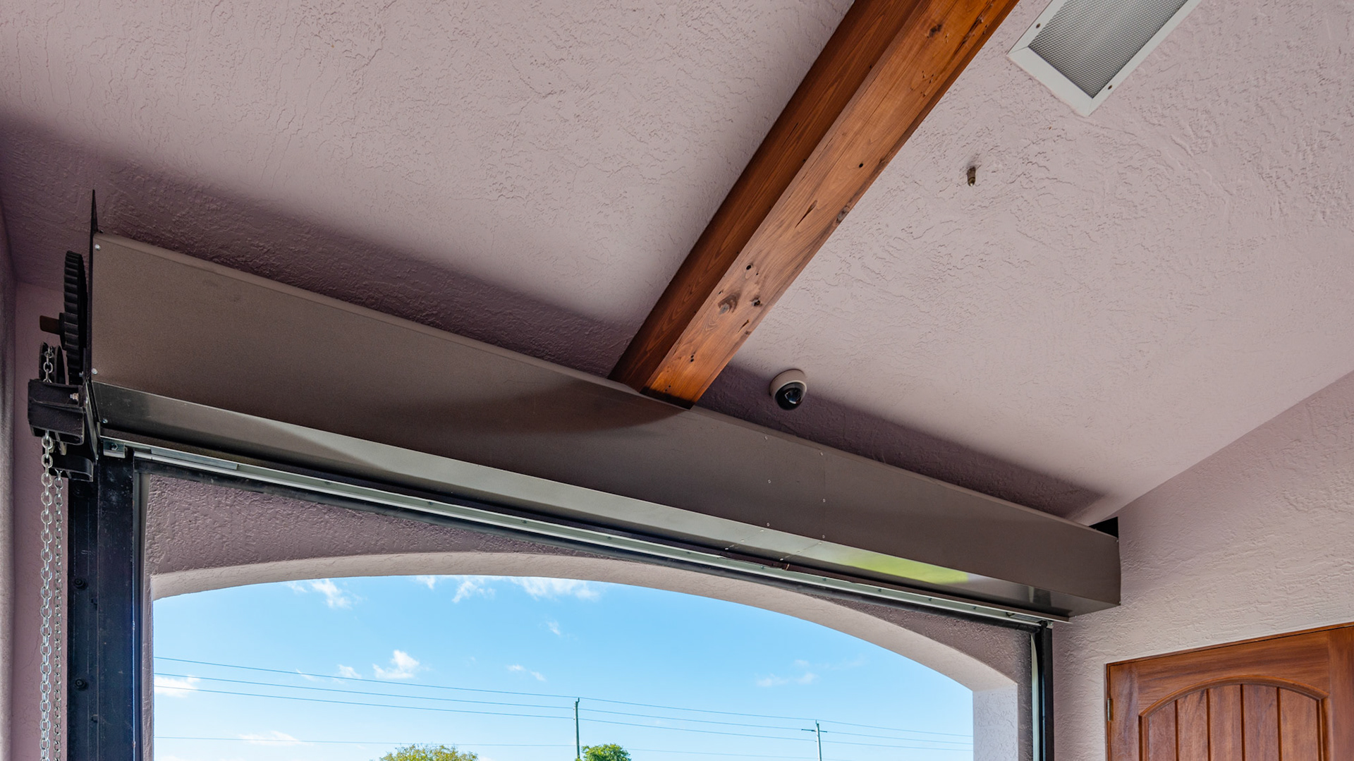 Hurricane door rolls up over the doorway. Note the security camera in the ceiling.
