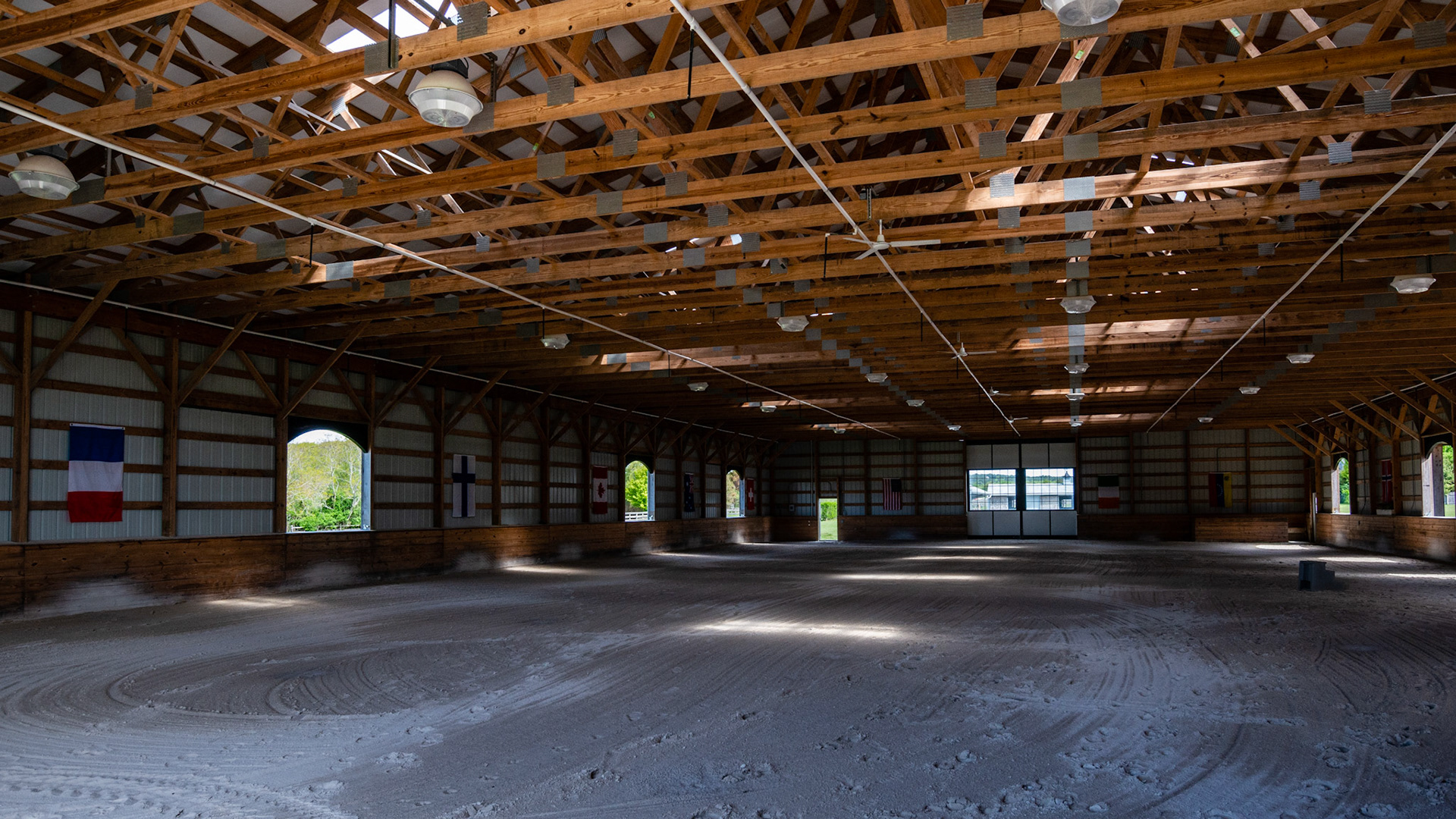 A Covered arena in NY with a ceiling irrigation system and small fans.