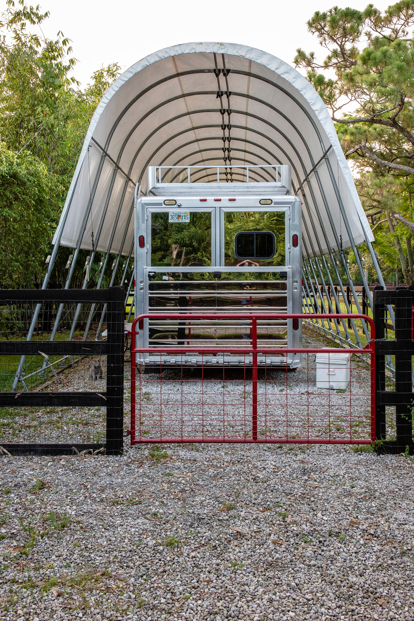Trailer tent covering in a Quonset style. Struts are anchored deep in the ground to brace against strong winds.