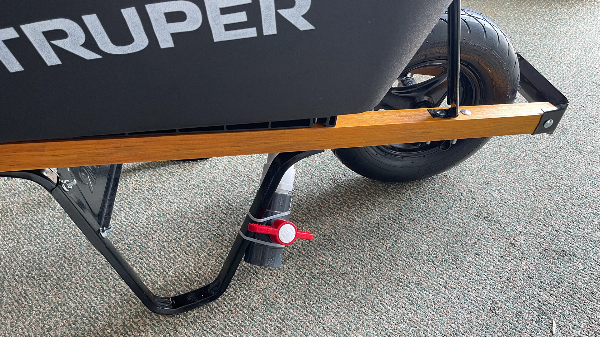 The piping below a 3 inch shower drain placed in the bottom of this wheel barrow.