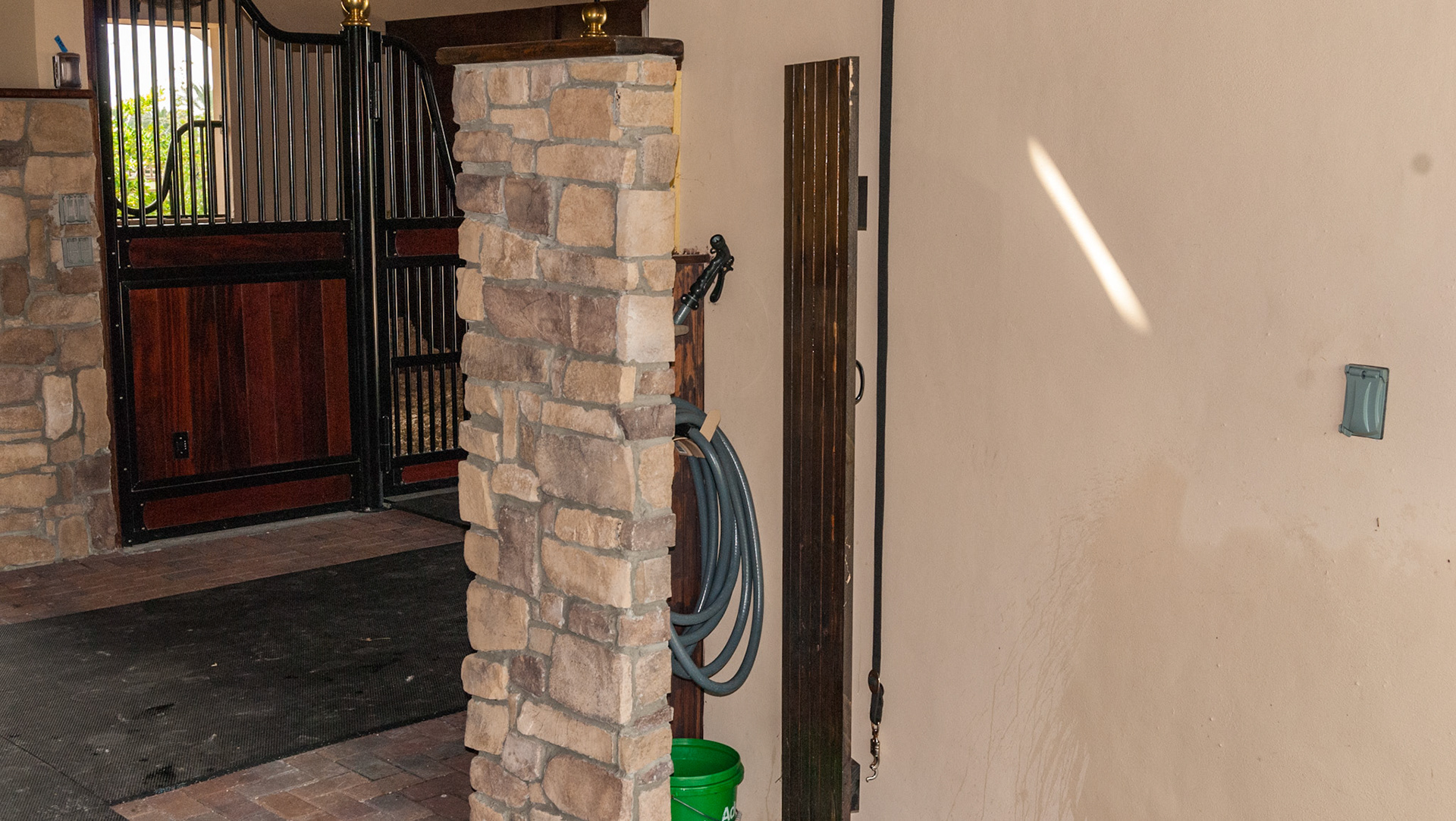 Wash area with hose located behind a door.