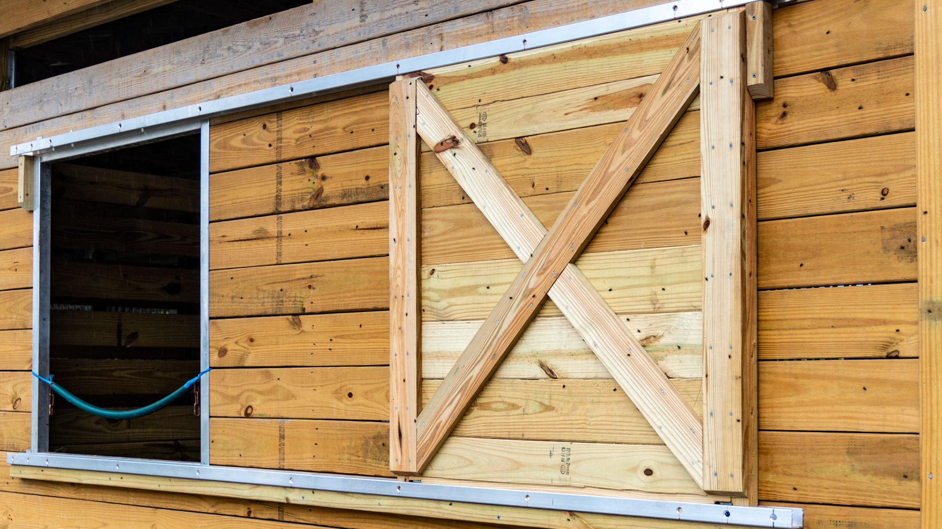 Metal trim in a brand new barn in Loxahatchee, FL - sliding outside stall window cover.