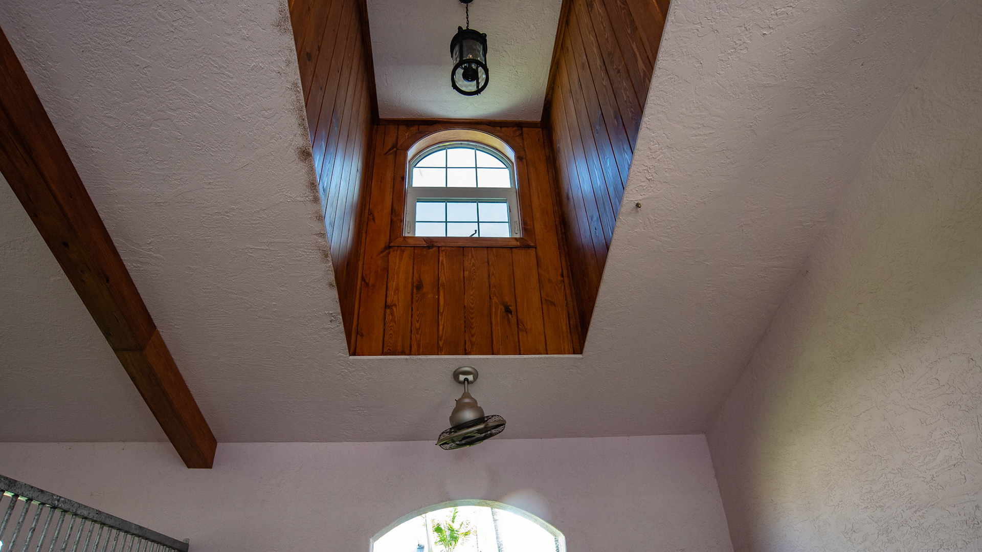 The ceiling fan oscillates distributing the flow of air evenly over the stall in the hot FL weather. The ceiling window adds light but not direct hot sun rays during summer. It is interesting that dirt accumulates along the edge of the stucco ceiling.