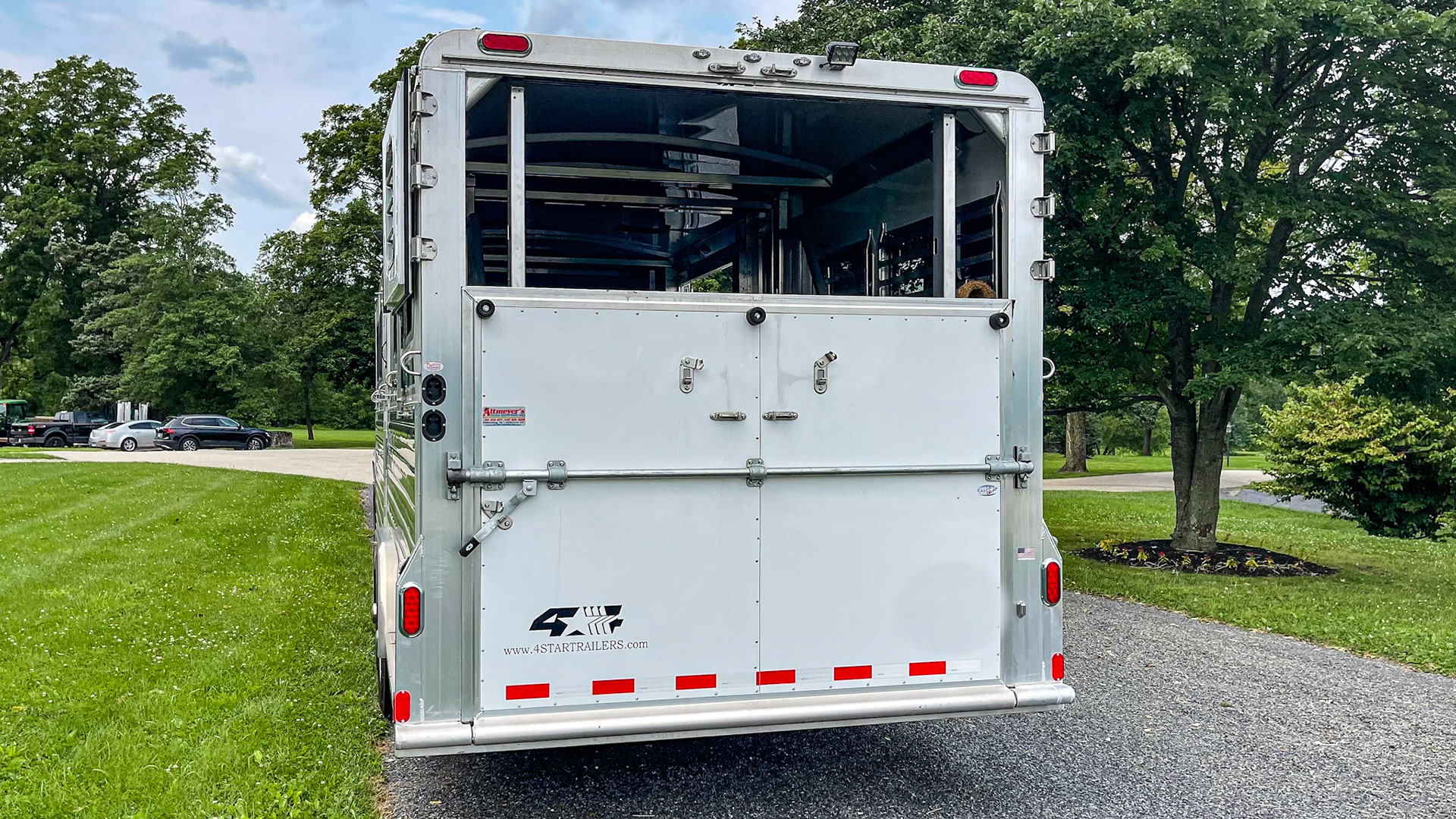 A gooseneck trailer on a pickup truck. This rear loading ramp has a single operating lever and upper doors that can fully open or close.