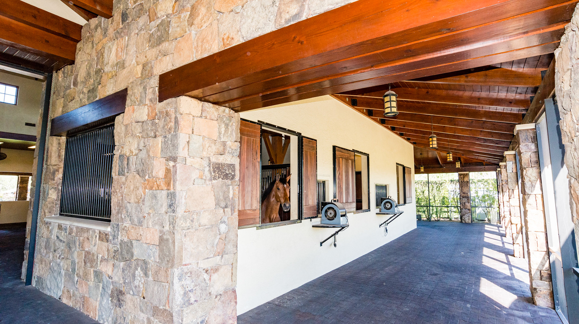 Cut stone facade, outer walkway, rubber floor, screened outer wall, blowers fans set on corner-less stands.