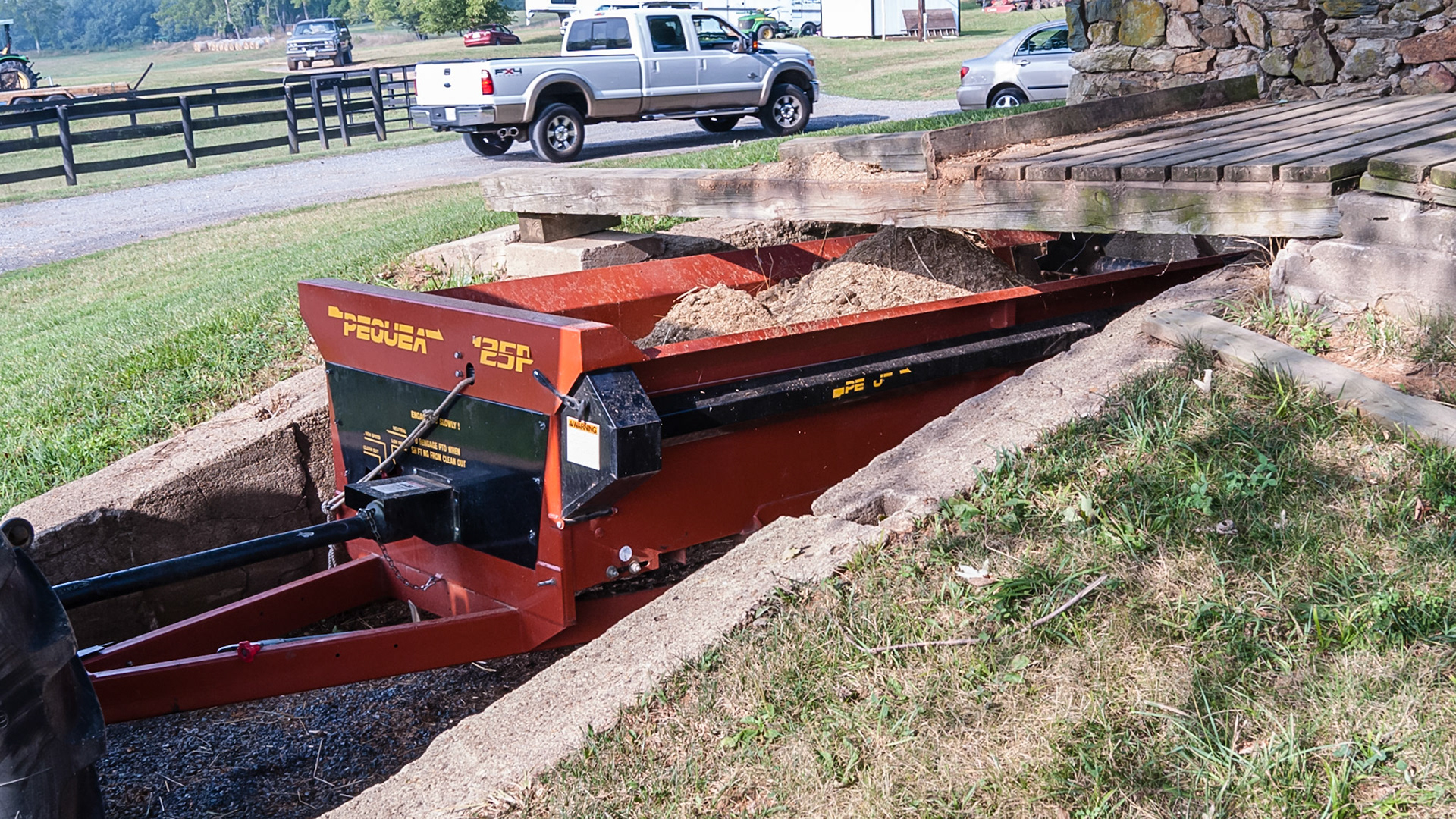 The spreader parks under the ramp and can be moved to allow for complete filling , the wheel barrow stop is tall enough to be effective.  There is no grade up to the platform.
