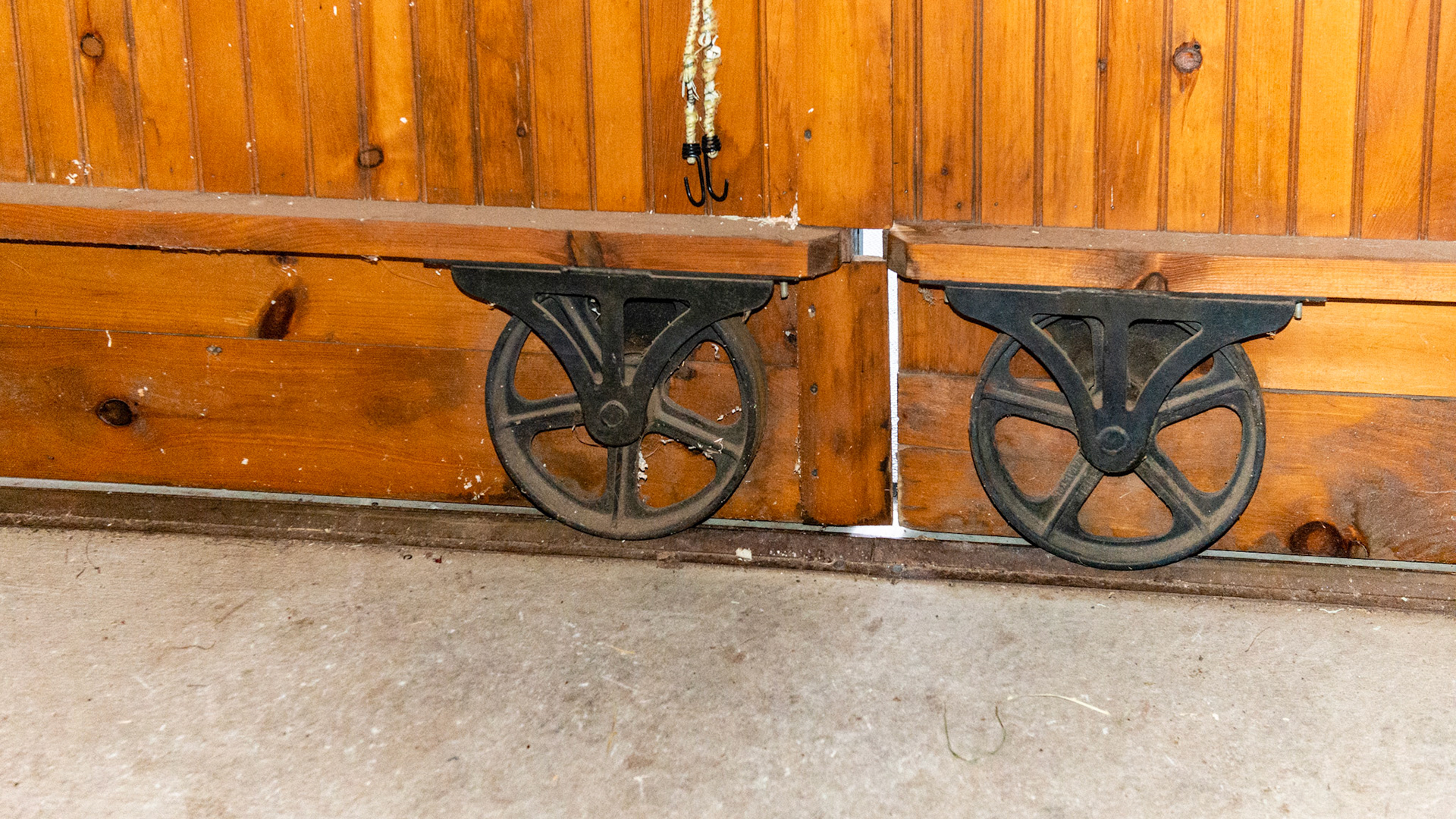 Large metal wheels help roll this door along a track.