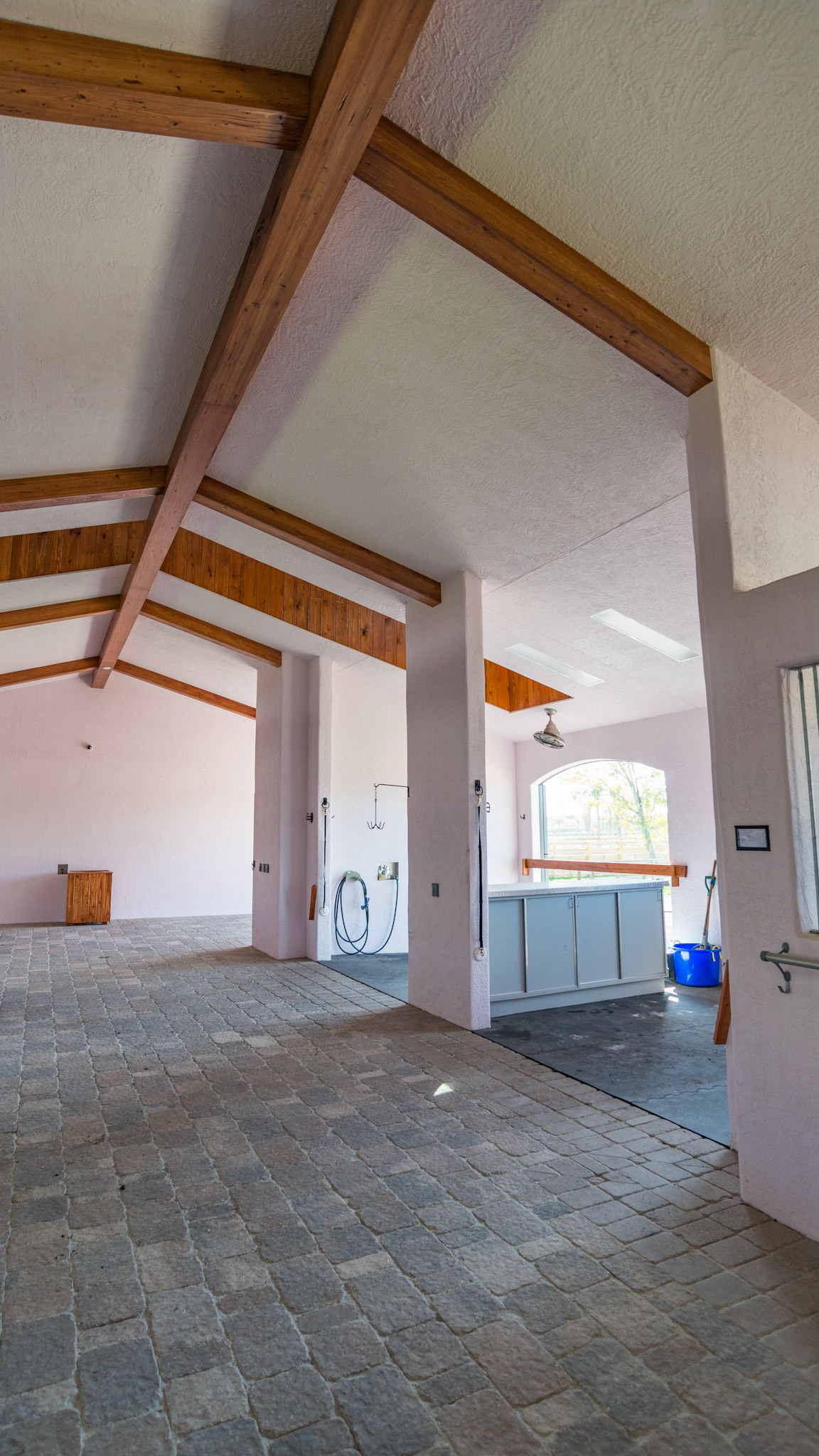 Stall interior with stone flooring and a stucco ceiling.