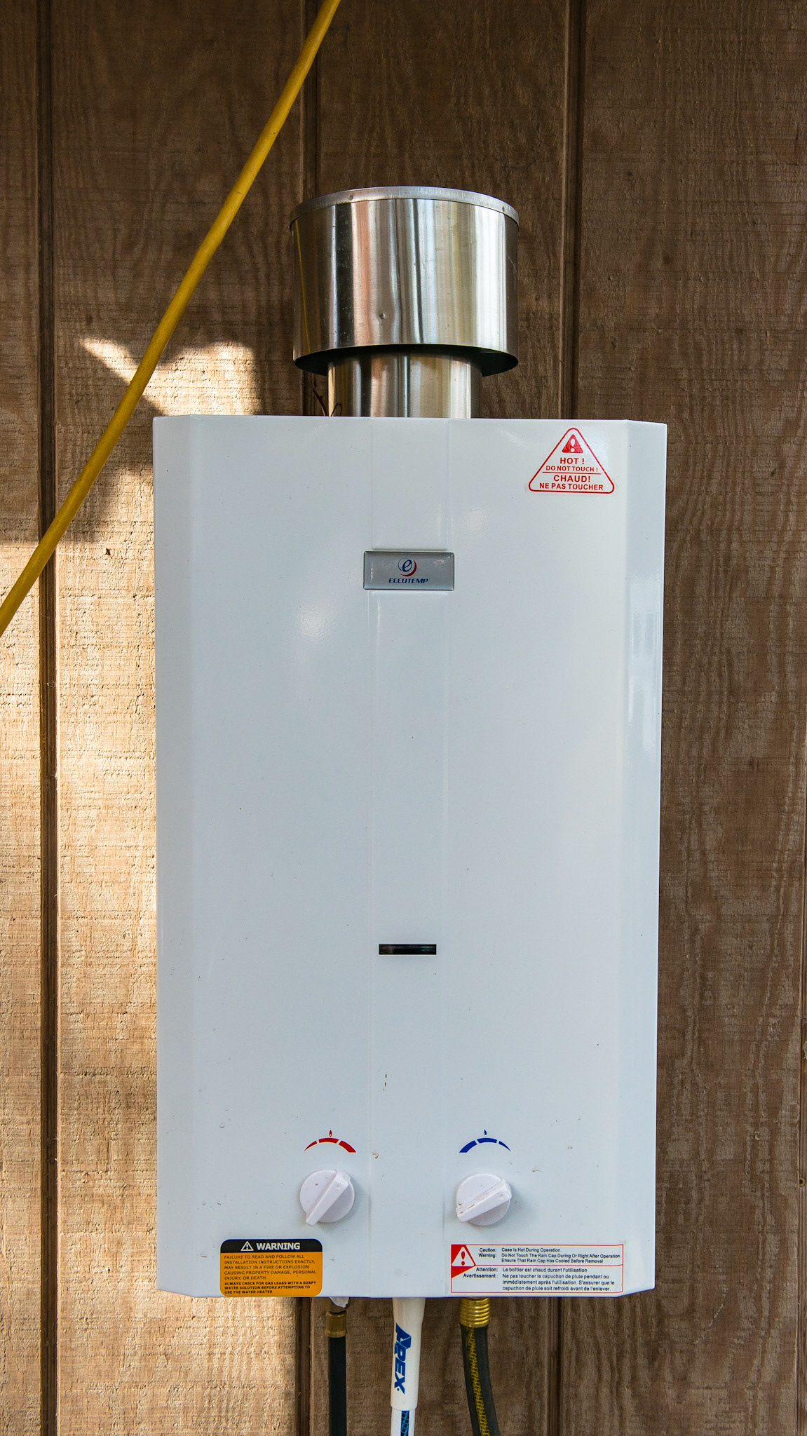 A Propane driven instant hot water heated mounted on the side of a barn. The cost was $138 on Amazon.  It worked beautifully in the 40 degree morning.