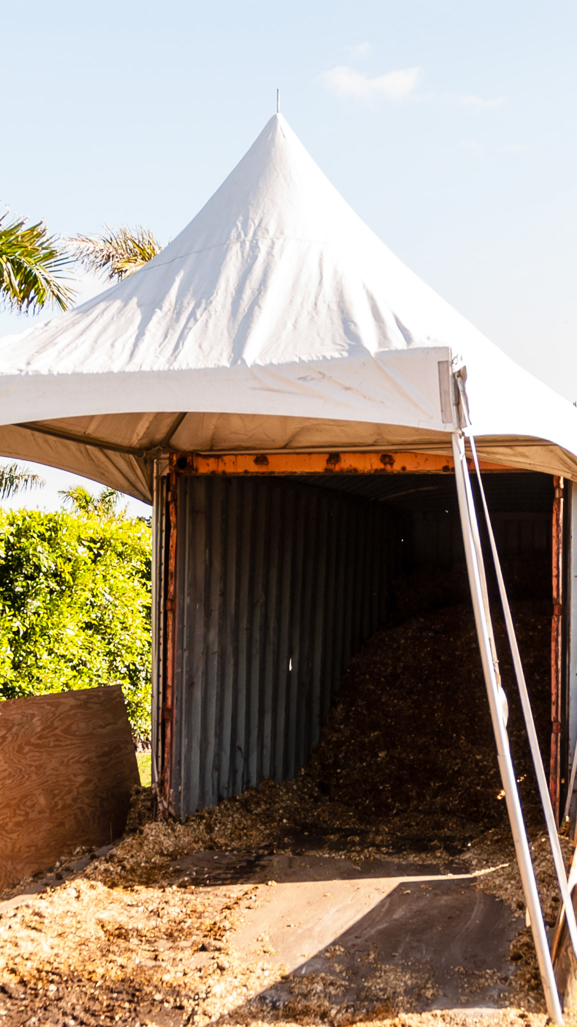 A tent provides shade and a dry entrance to this container.