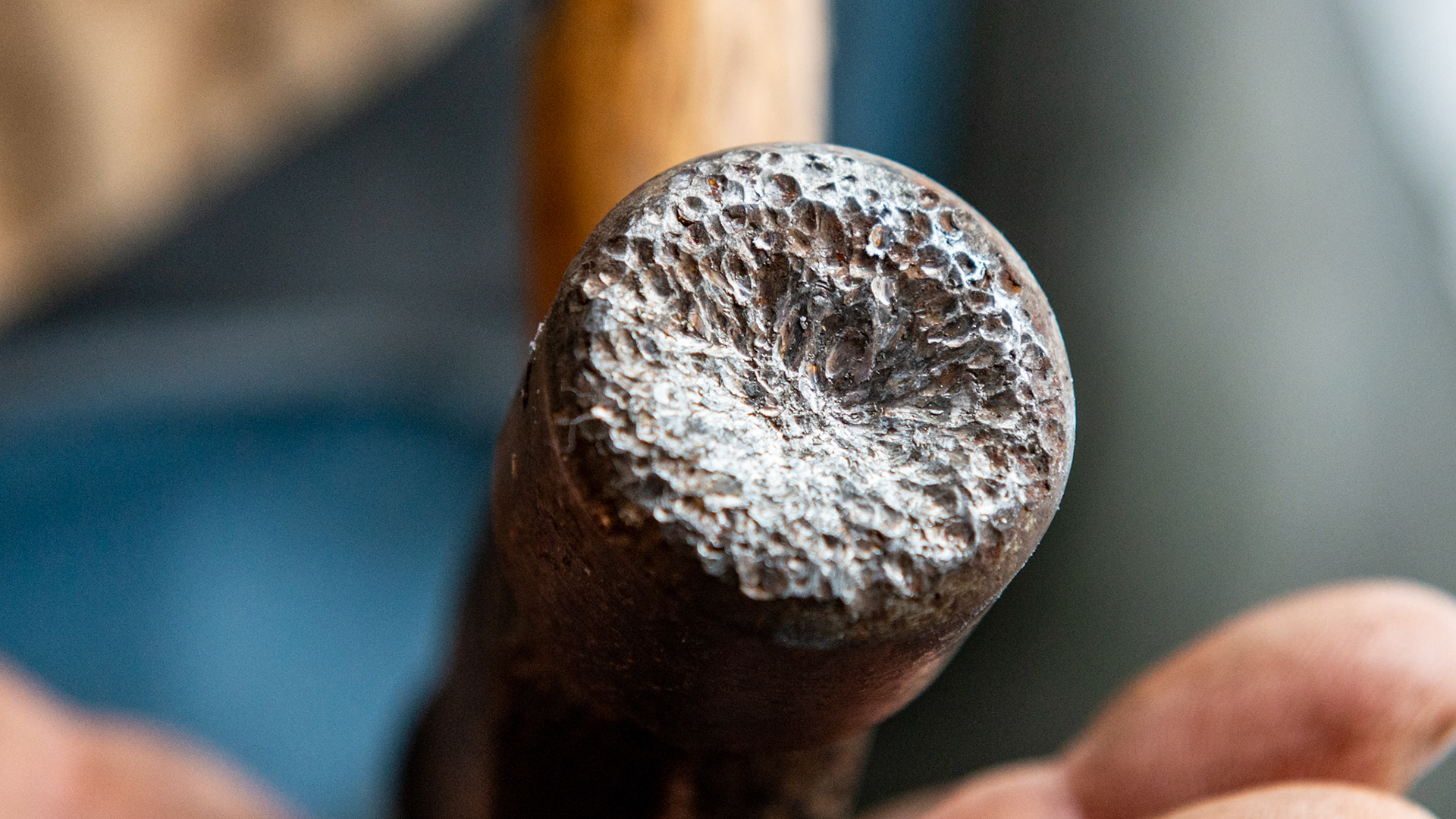 This "cheap" hammer is used only to drive Borium studs into shoes.  The Borium is so hard that it divots and cups the surface of this steel hammer.
