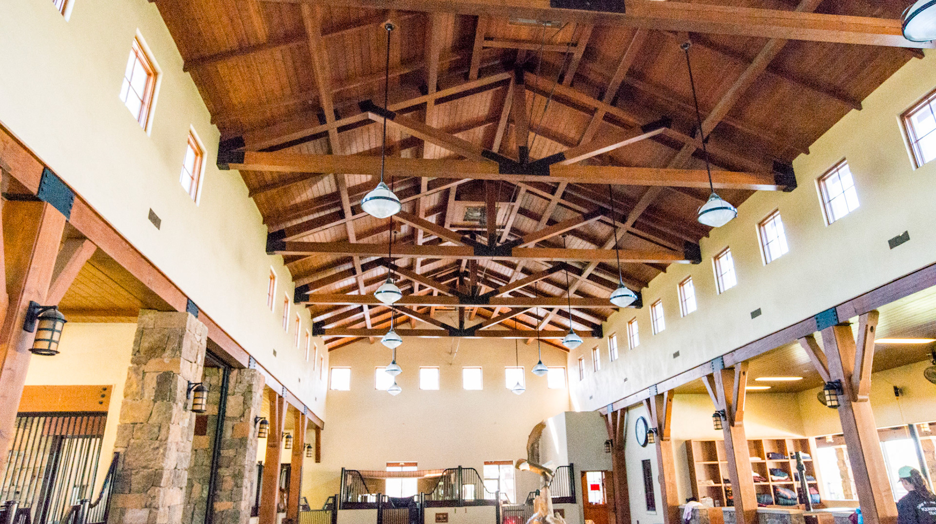 Barn interior - Timber ceilings, surrounding ceiling windows, stalls form a courtyard with a statue of a bald eagle in the center.