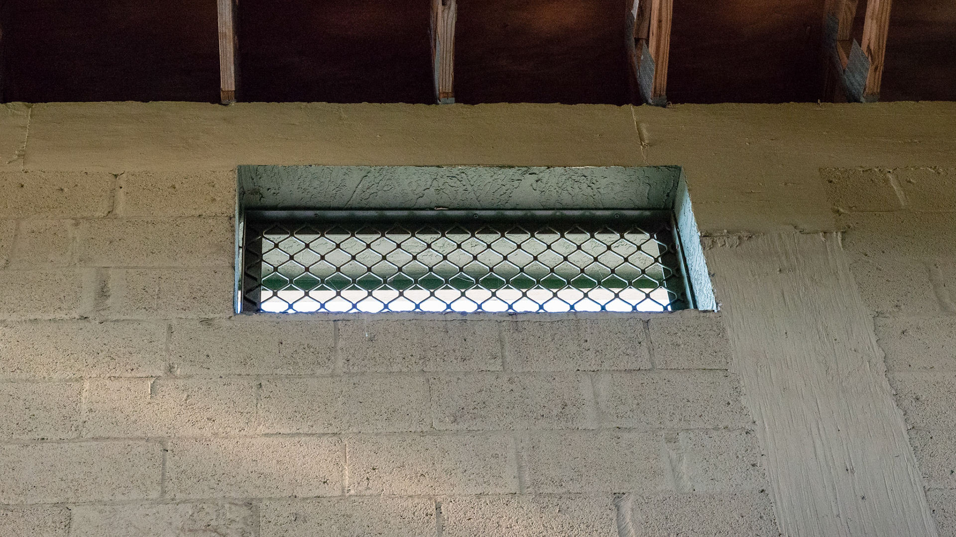 Steel grating covers the windows near the ceiling.