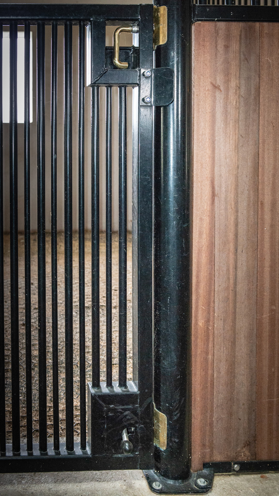 This stall door has the normal spring loaded latch at wiast level for daily use. It also has a second floor level, spring loaded safety latch that can be locked in the open position by foot for the day or closed at night for added safety.