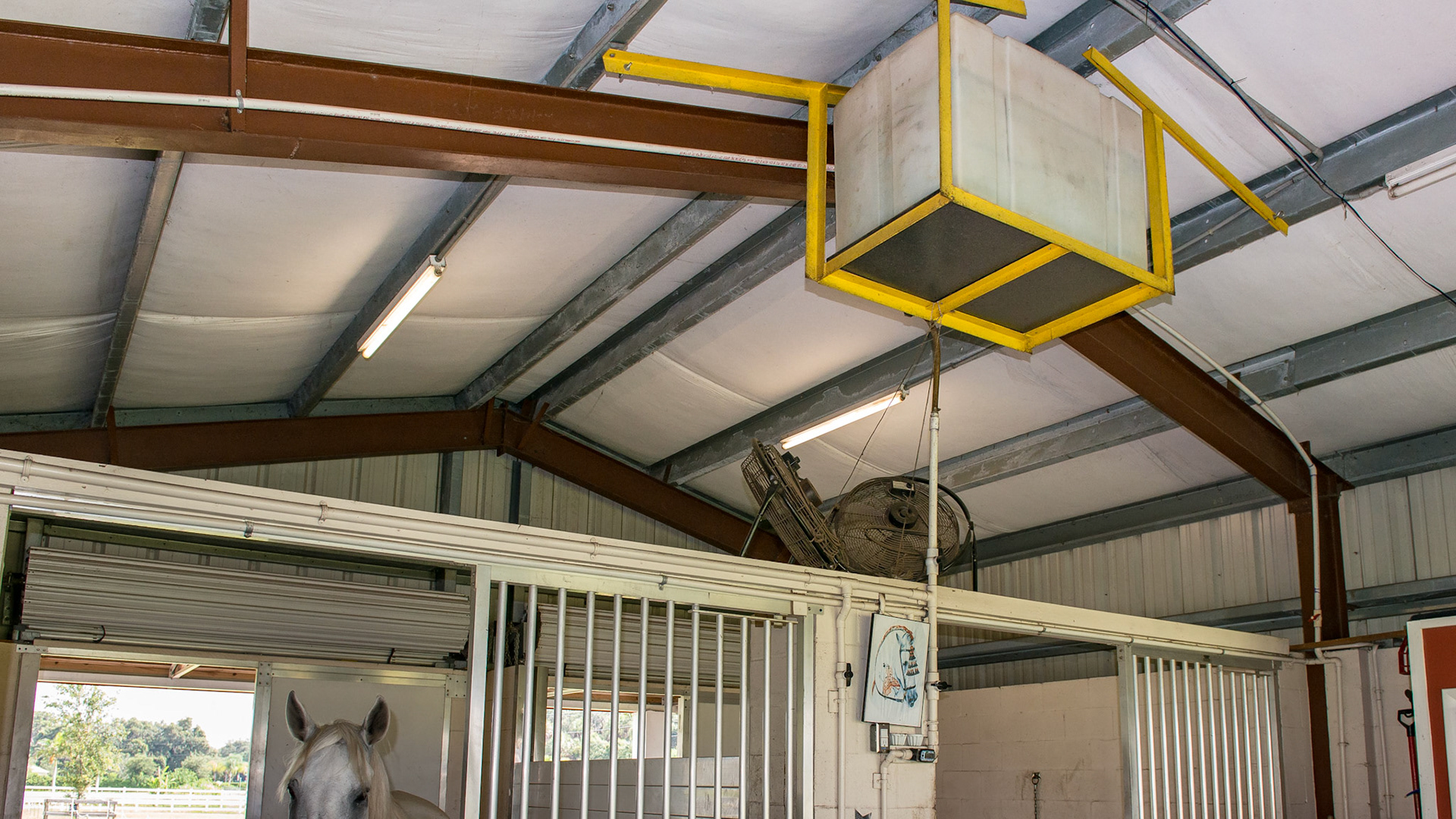 The ceiling mounted water reservoir with gravity feeds to the stalls.