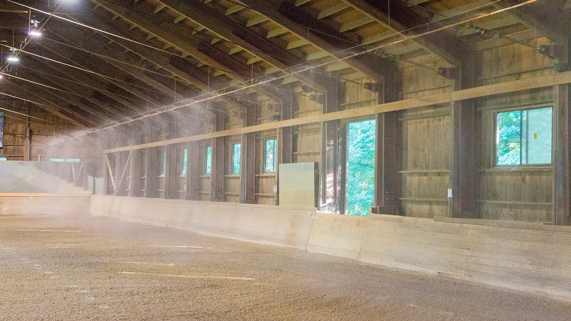 Rain falls from the ceiling irrigation system in this covered arena.