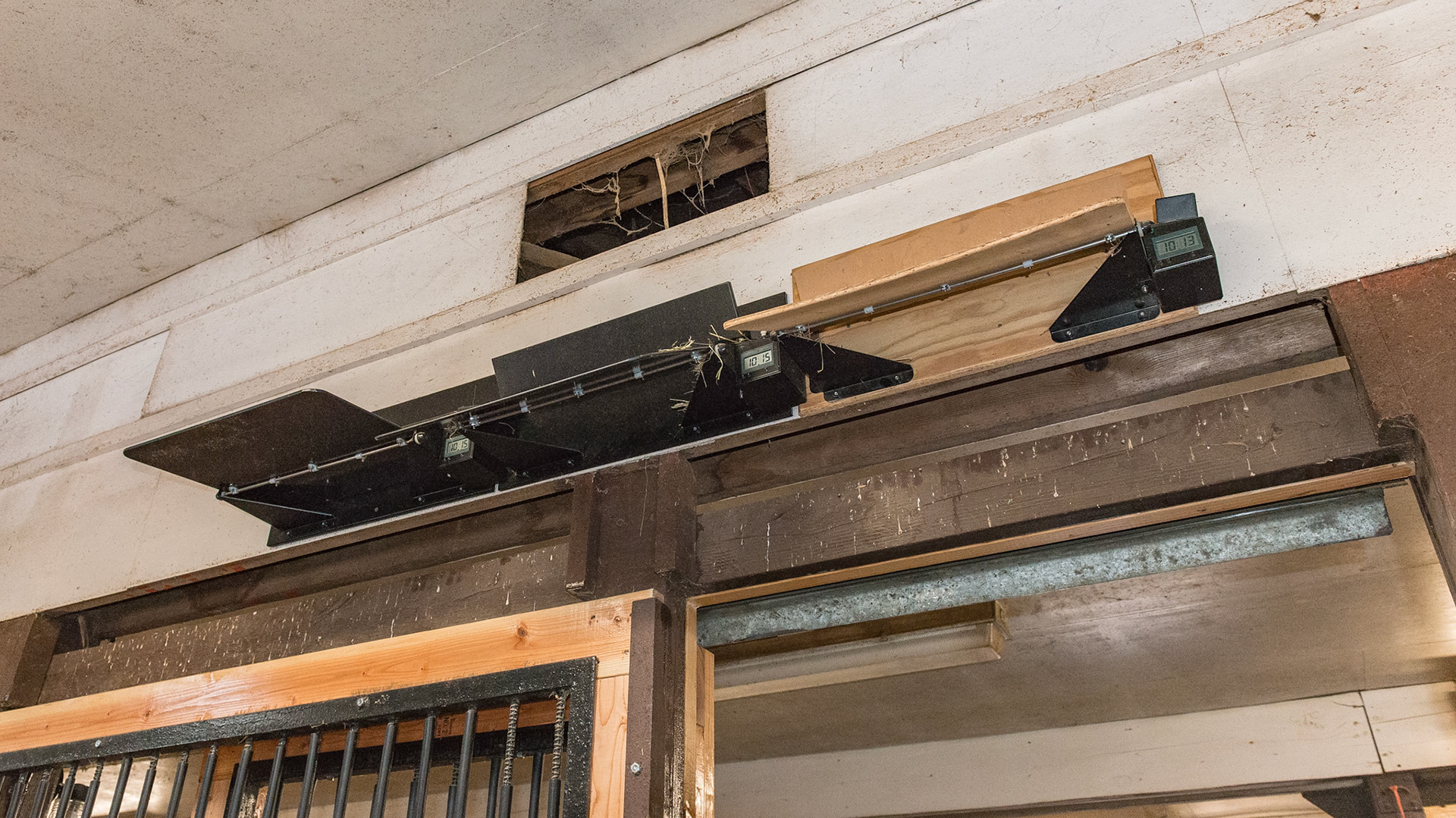 Hay feeders on a timing mechanism delivers 2 pounds of hay three times a night. They are loaded by lifting via pitchfork. the timer activates a solenoid releasing a lock. The weight of the hay tilts the tray and the hay falls into the stall.