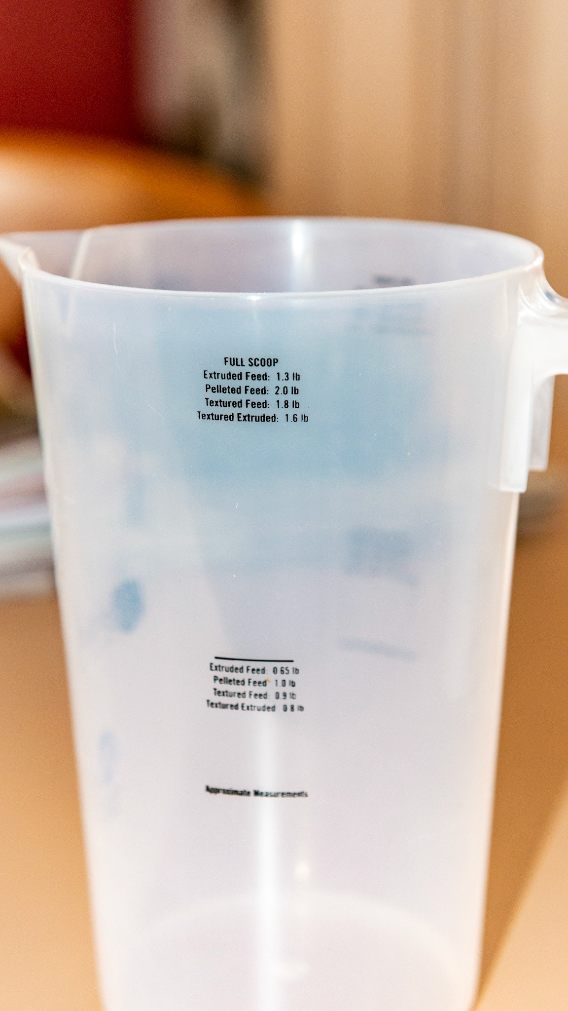 A feeding scoop for grain with measurements in weight and volume fulfilling the plea: "Feed by weight, not by volume."  Note that the denser the feed the more weight assigned to the line (volume).