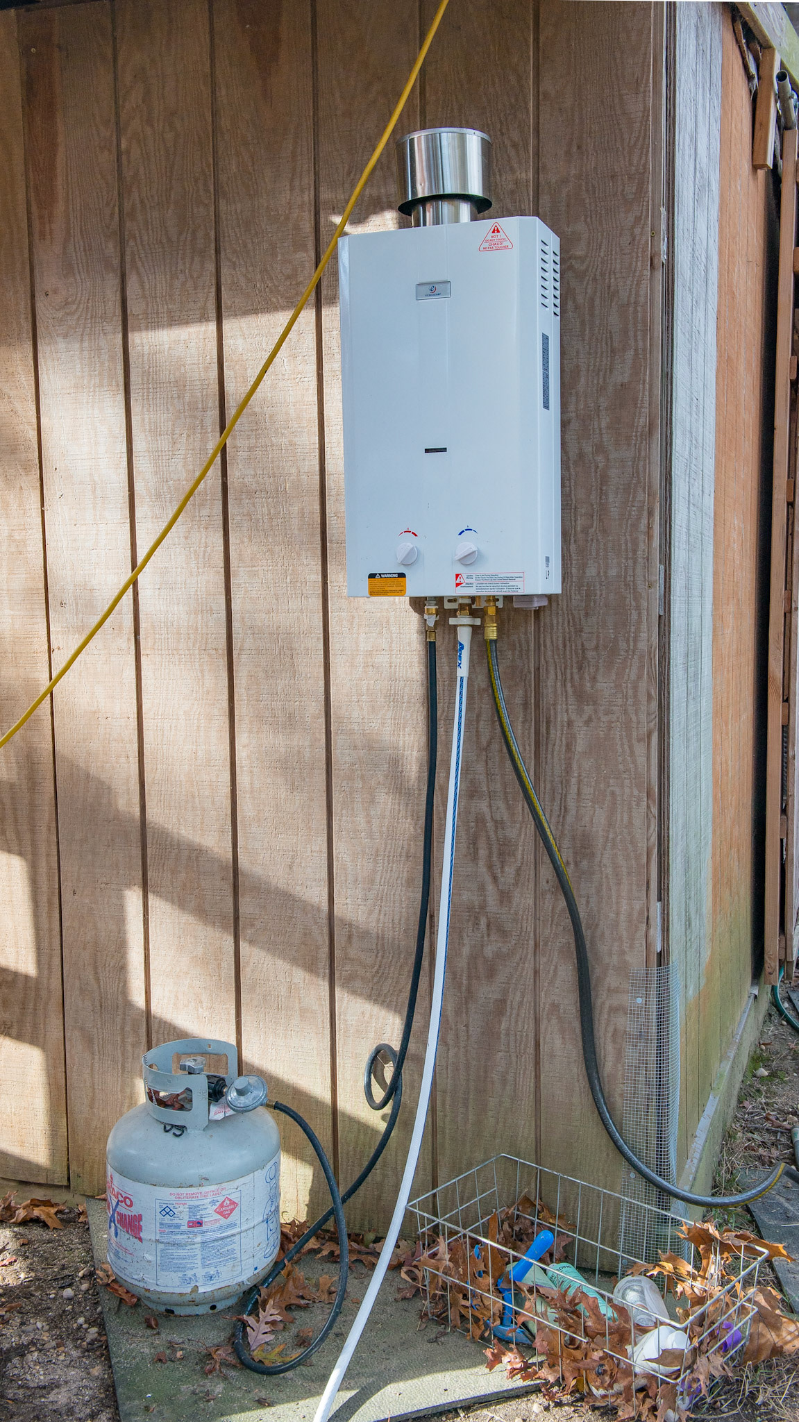 A Propane driven instant hot water heated mounted on the side of a barn. The cost was $138 on Amazon.  It worked beautifully in the 40 degree morning.