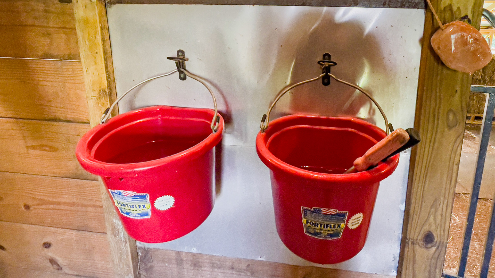 A stainless steel sheet is placed behind these water buckets to preserve the wood and to allow for easy cleaning.