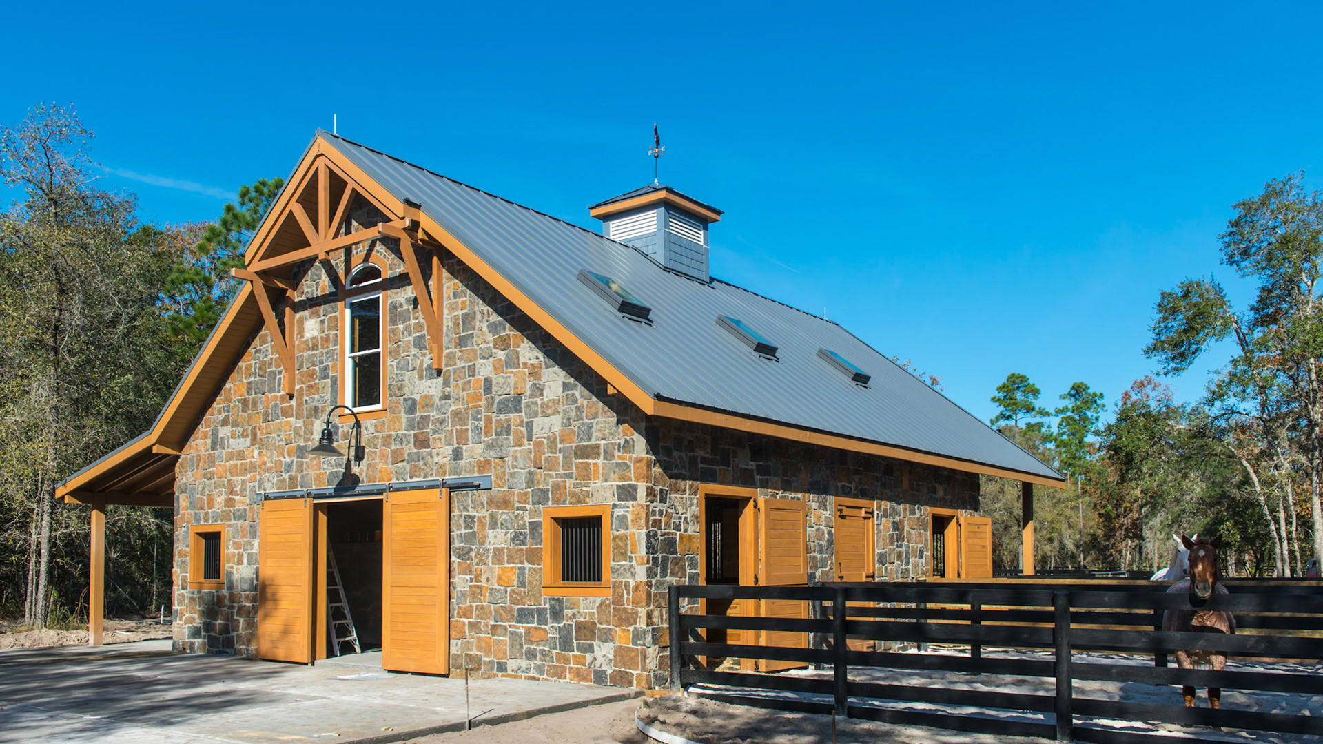 Stone facing and exposed stained wood create a beautiful custom made barn in northern Florida.