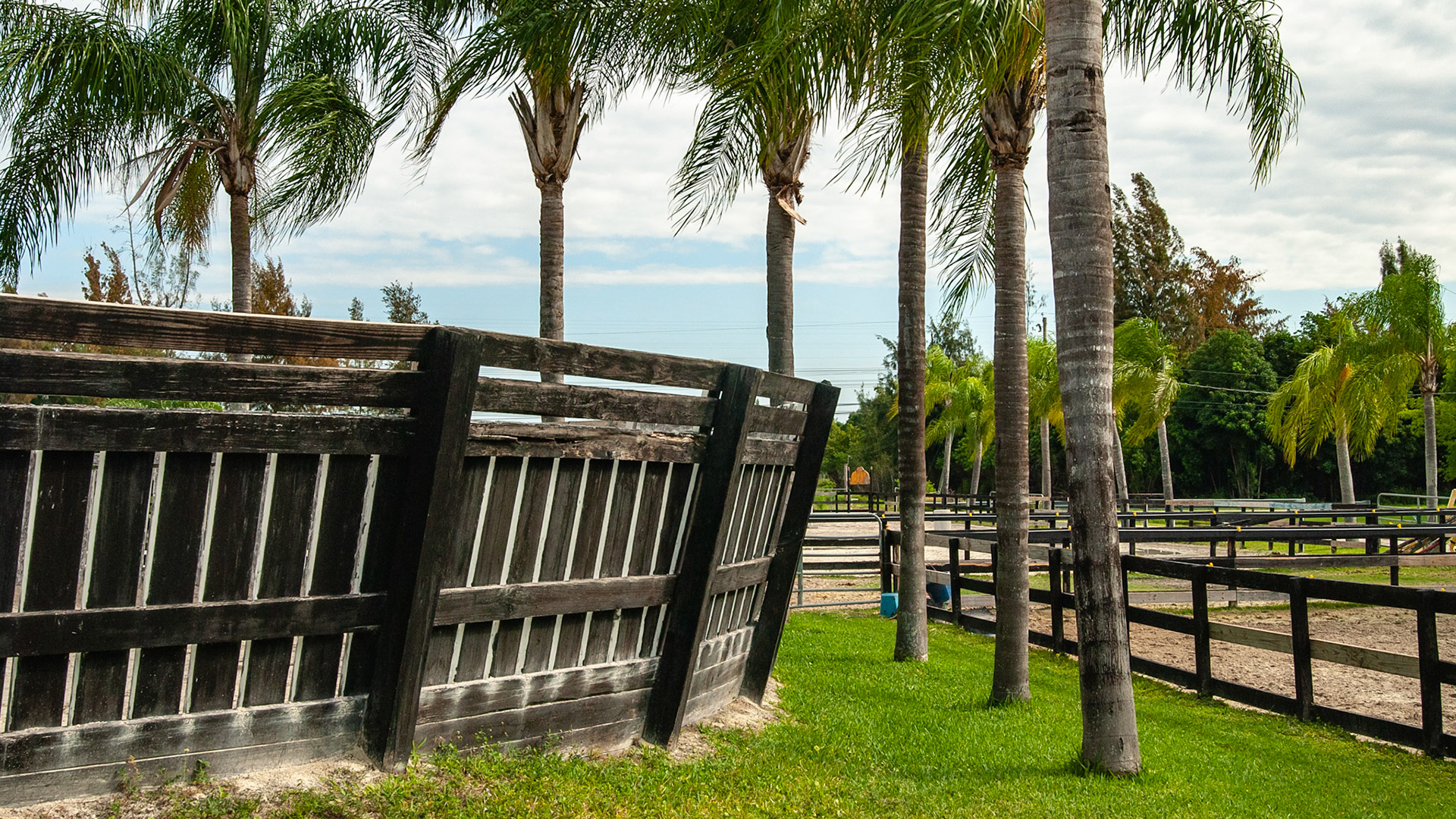 Board and post round pen with vertical boards and slanted sides.