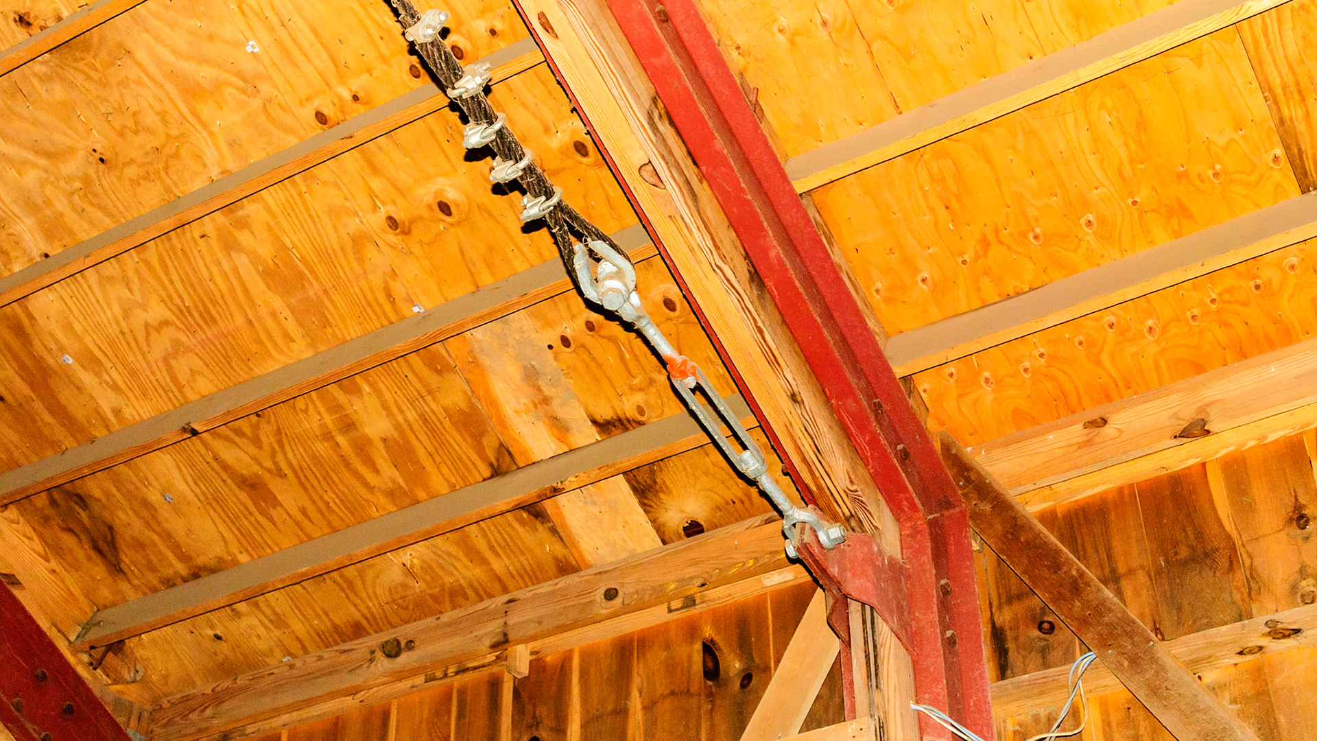 Custom made metal truss braces.  Cabling applied to prevent spread of the walls due to a snow load.