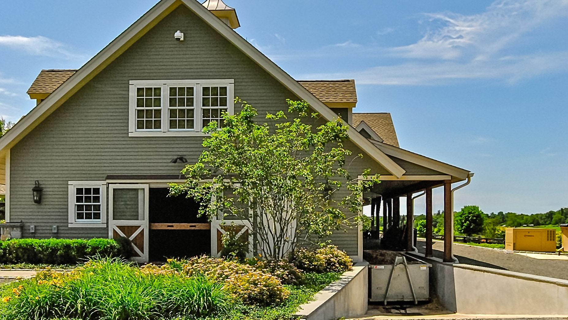 Security cameras mounted cleanly in high places. Backup emergency generator sets away from the barn.  This roll off container sets at ground level.